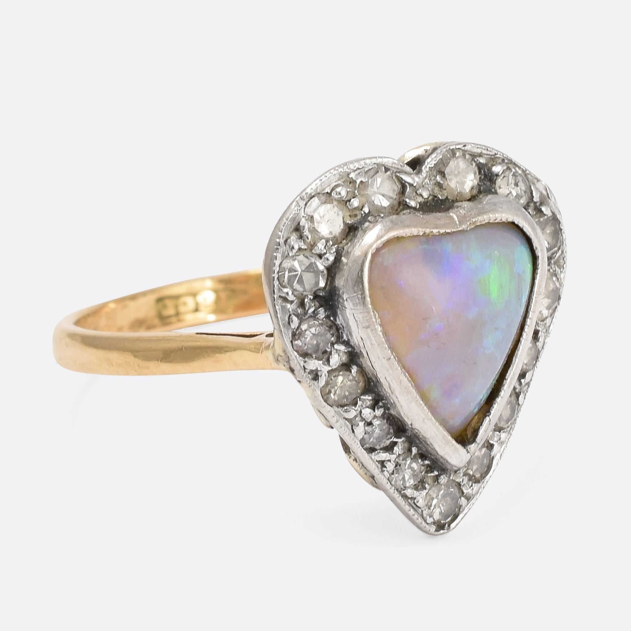 This beautiful antique ring is modelled with a heart-shaped head, set with diamonds and a heart-shaped opal. The simple band is crafted from 18ct yellow gold, with the stones set in silver. The back of the head is nicely galleried, allowing light in
