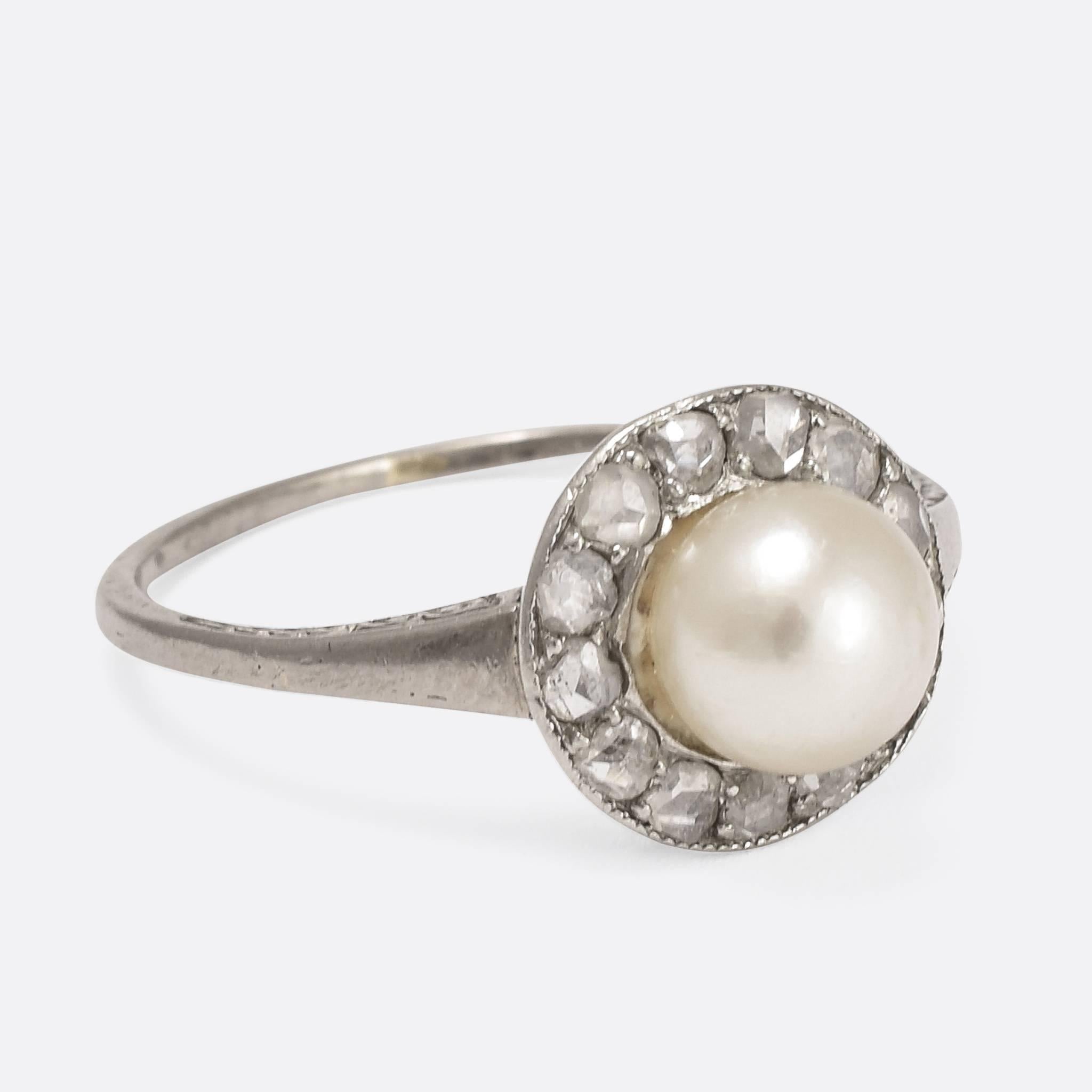 Superb Art Deco period cluster ring, set with a 6.2mm natural pearl surrounded by a halo of glistening rose cut diamonds. The ring is modelled in platinum, and features pretty hand-chased detail to the shoulders and a galleried head. Ring Size: US: