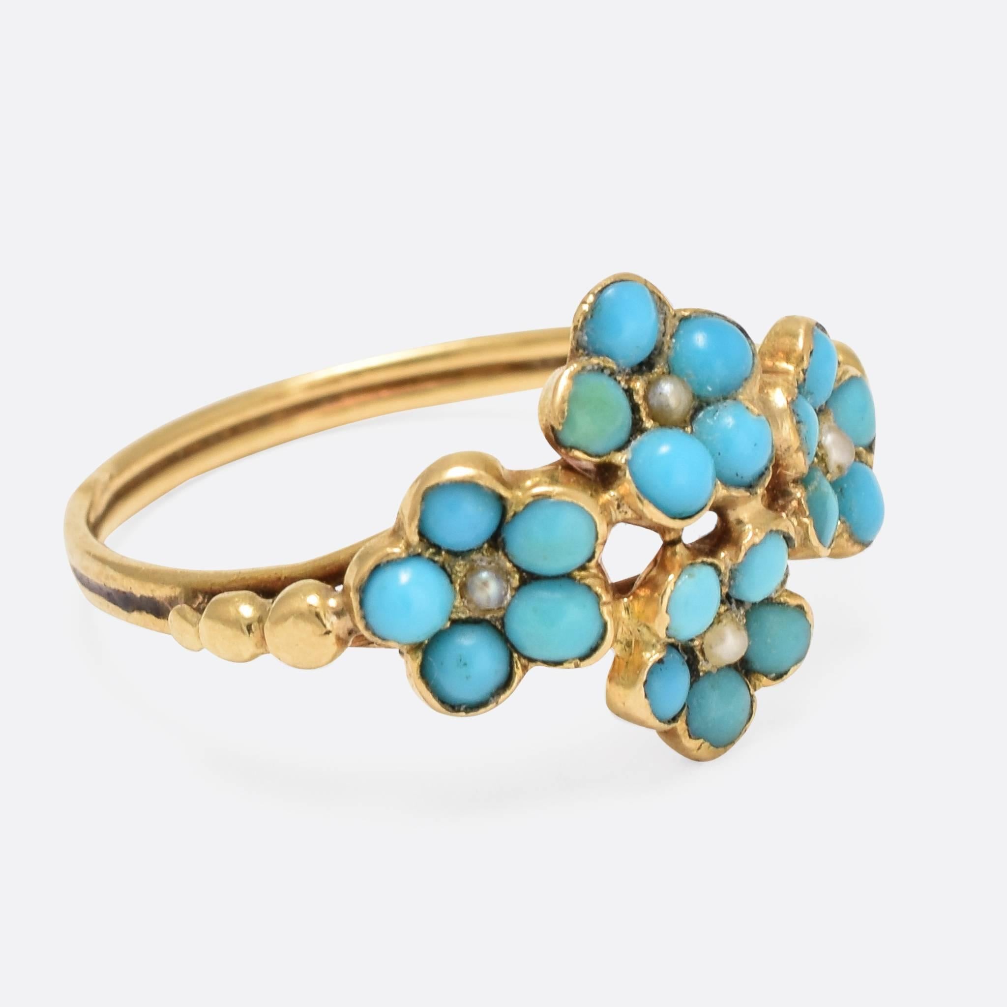 This pretty antique ring was made in France in the latter part of the 19th Century. The head features four flowers, each set with a pleasing cluster of turquoise cabochons and seed pearls. The twin band holds nice pommel detail on the shoulders, and