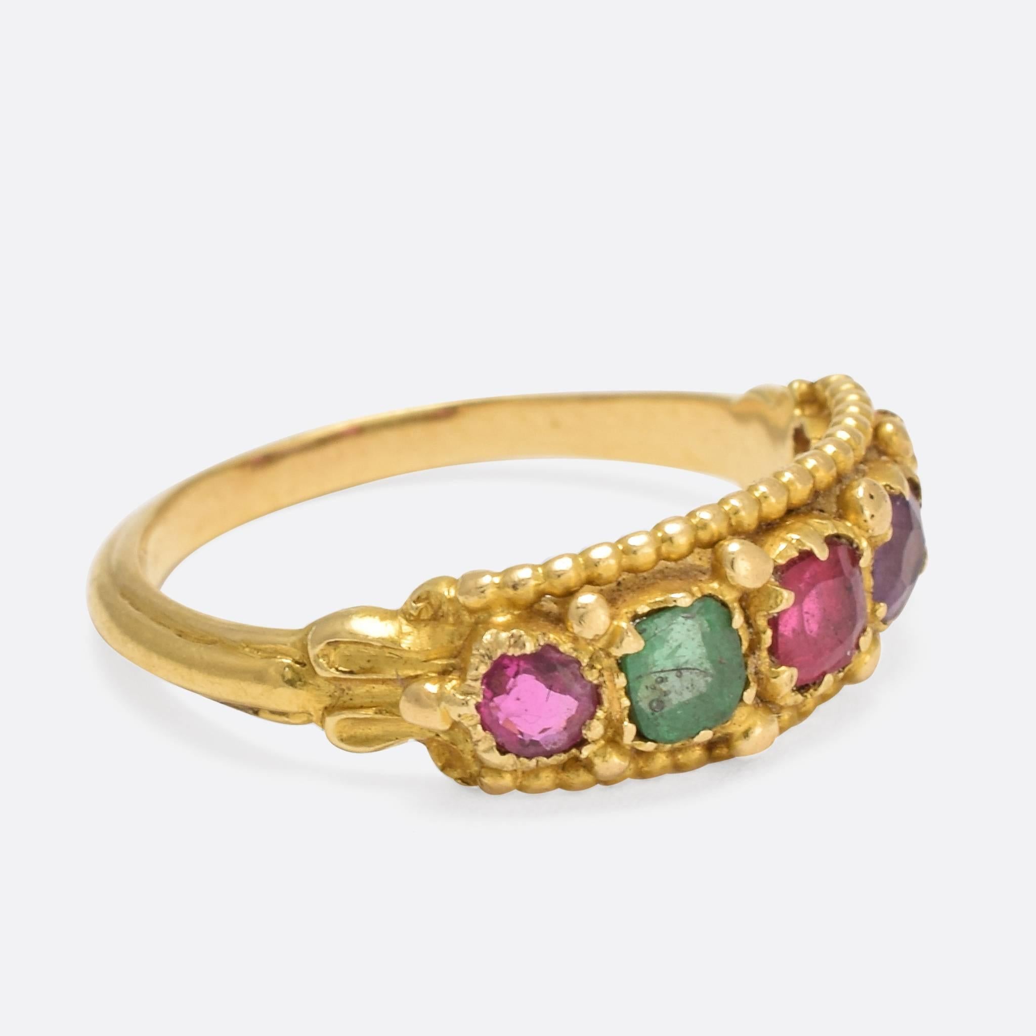 This pretty antique ring was made in England at the height of the Etruscan Revival - c.1880. It is set with a selection of colourful gemstones: ruby, emerald, garnet, and amethyst, and features the pommelled goldwork typical of the style. Modelled