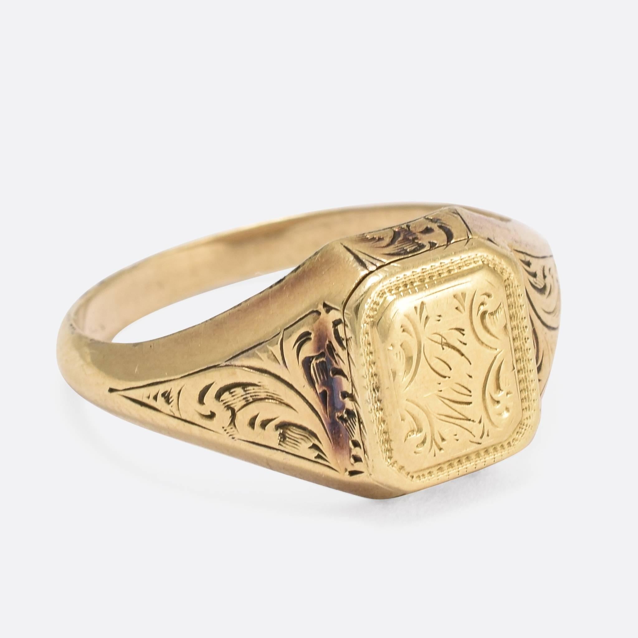 This fabulous antique signet ring features a hidden locket compartment on the face. The hinged front opens to reveal a small glass compartment. The shoulders and face are beautifully hand-chased, and the ring modelled in 15ct gold. Ring Size: US: