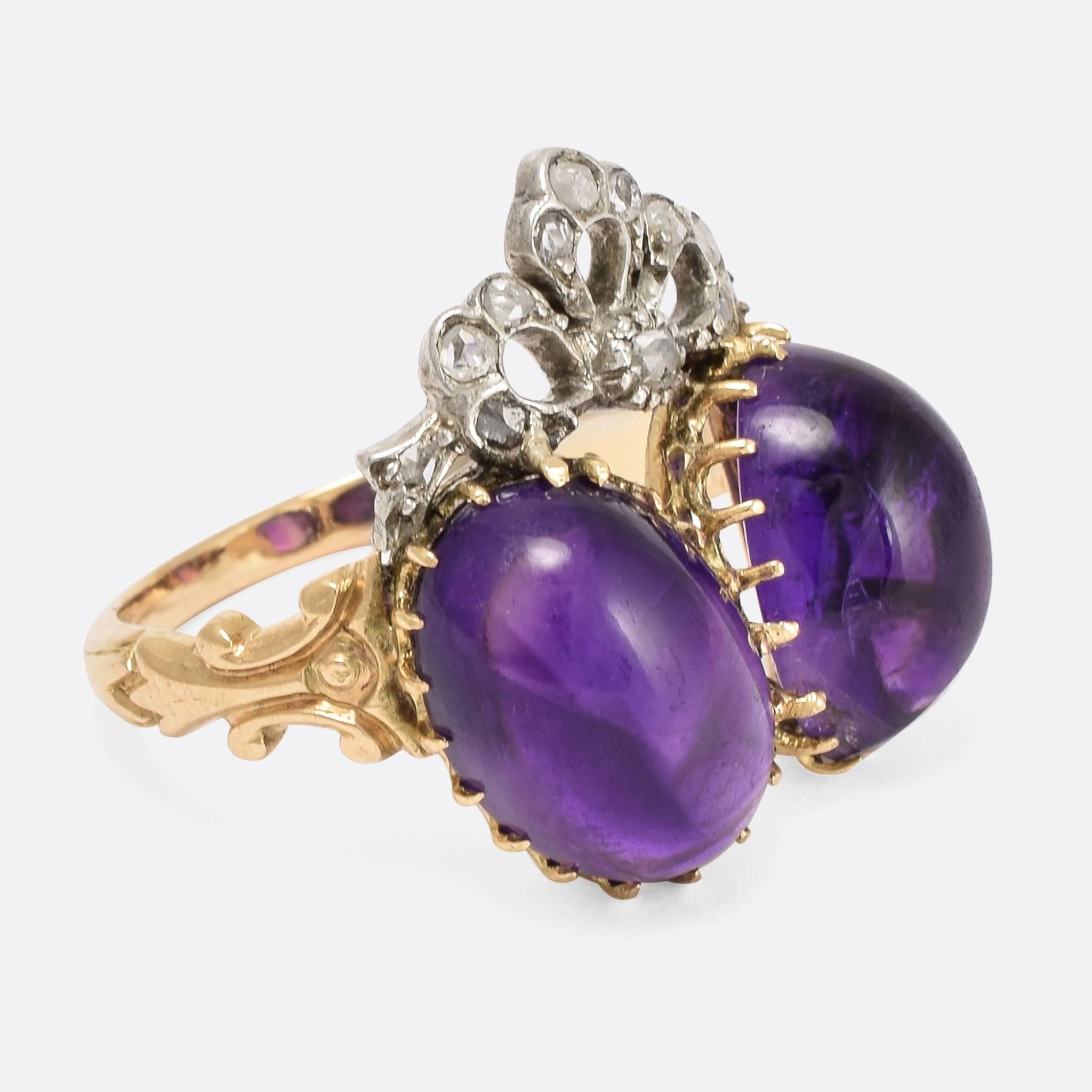 This magical ring is set with two oval-shaped amethyst cabochon stones, topped with a rose cut diamond set bow. The shoulder are beautifully detailed, with little scrolls, and the band is modelled in 15ct gold. A wonderfully romantic ring that is a