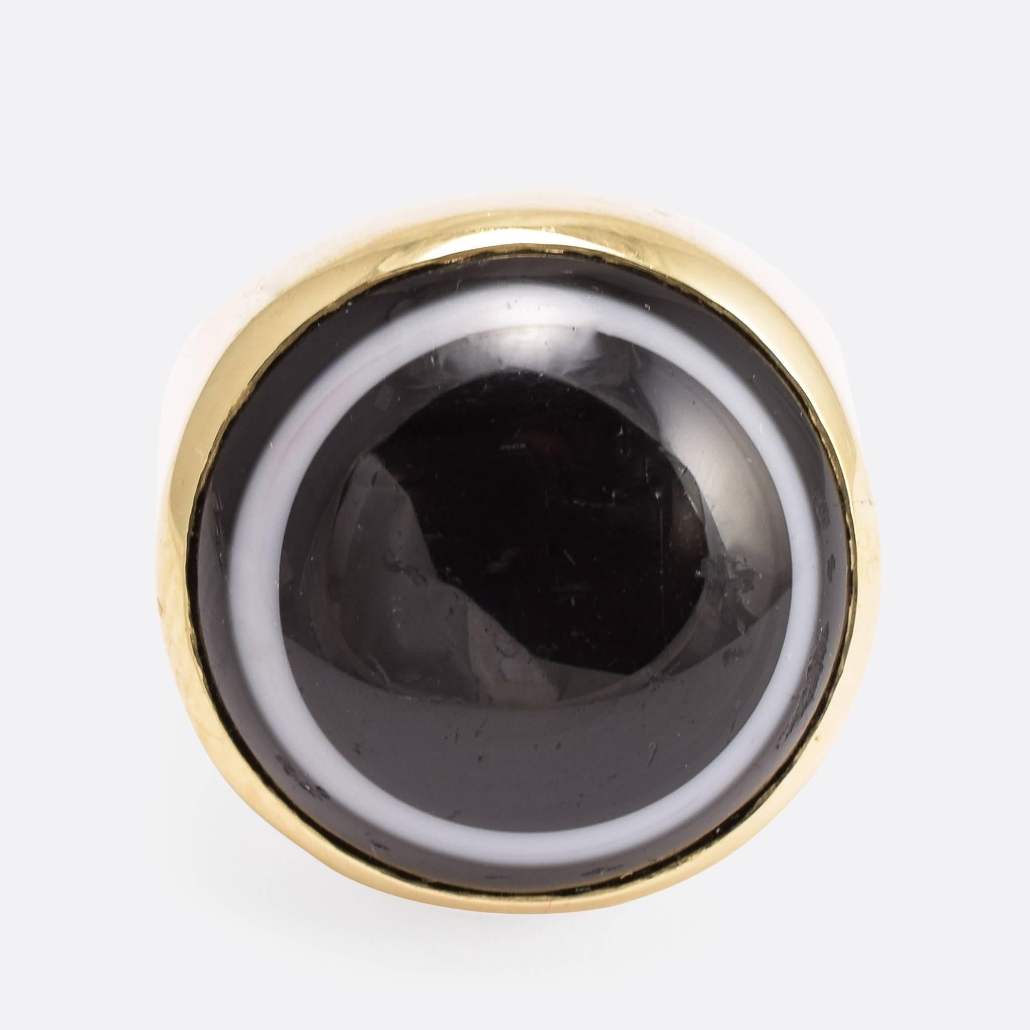 This fabulous vintage ring is set with an oversized banded agate cabochon, cut such that the white band forms a halo surrounded by black. The simple gold ring mount complements the stone perfectly. Ring Size:US: 9, or UK: R 3/4. Banded Agate: 2.0cm