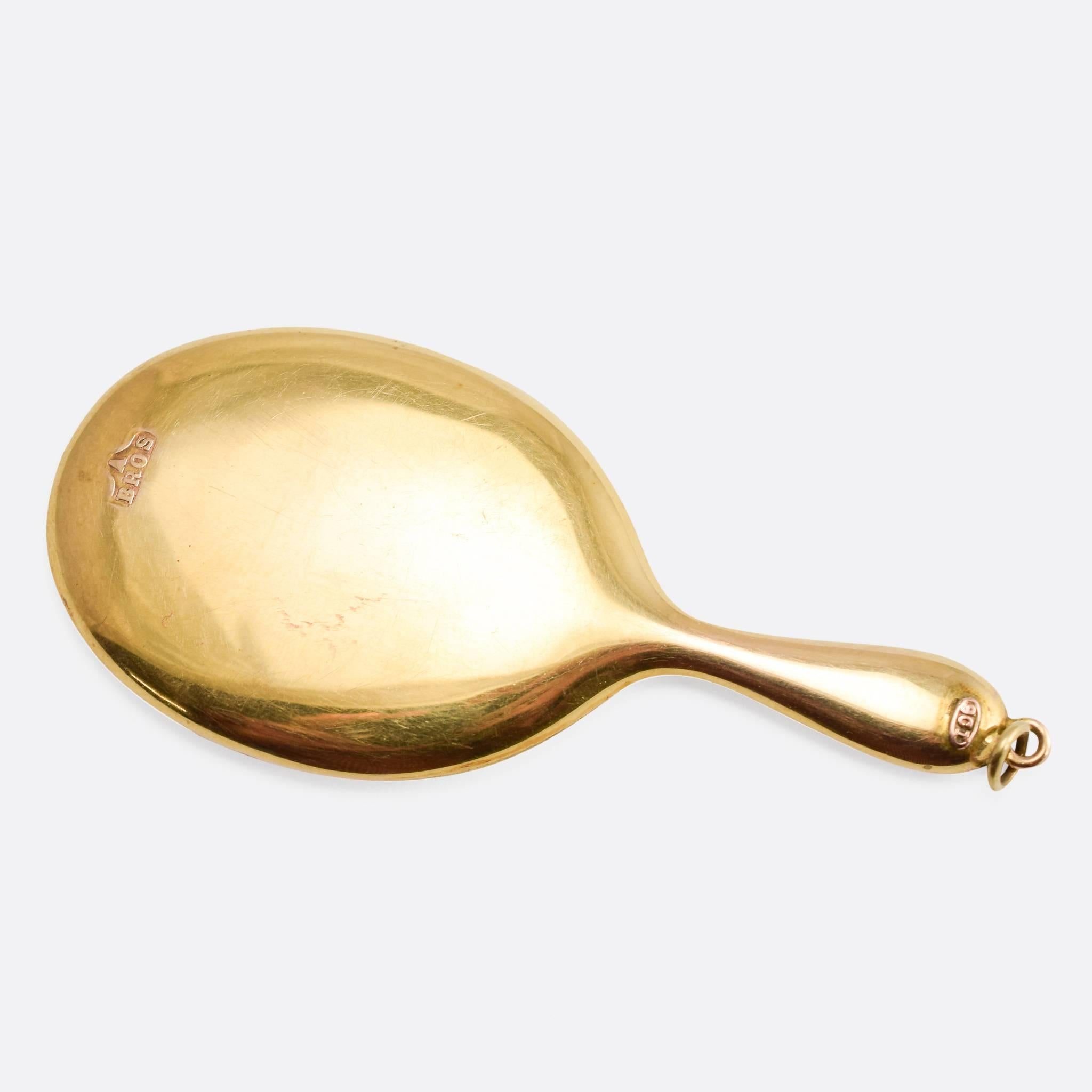 This antique pocket hand mirror is modelled in in 9ct gold, still paired with its original protective sleeve. It's made by the jewellery maker Abrahams Brothers, based on Vyse Street in Birmingham, likely in the early 1900s. With bail for wear as a