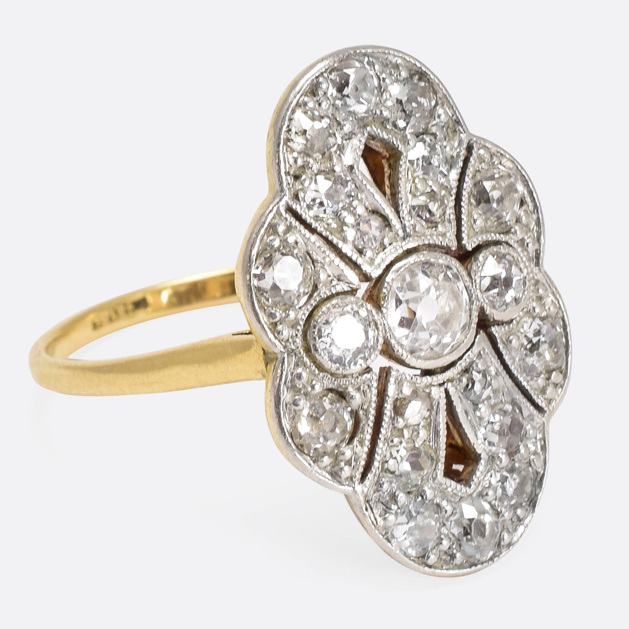This fabulous antique ring dates to the early 20th Century. The marquise shaped head is set with around 1.1ctw of old cut diamonds, in millegrained platinum settings. The back of the head features beautiful openwork, and the band is modelled in 18ct