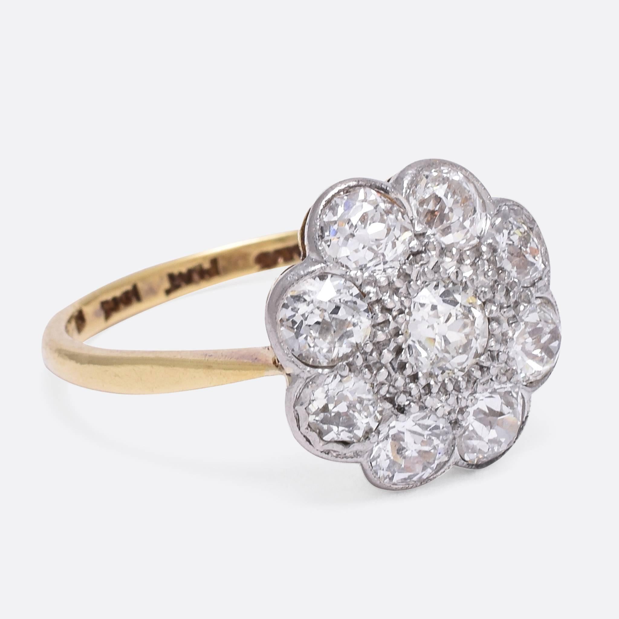 This magnificent antique daisy cluster ring is set with nine old European cut diamonds - 2.32 carats in total, including a central .40ct stone. The ring dates to the late Edwardian era - c.1910 - and is modelled in 18ct gold and platinum. The