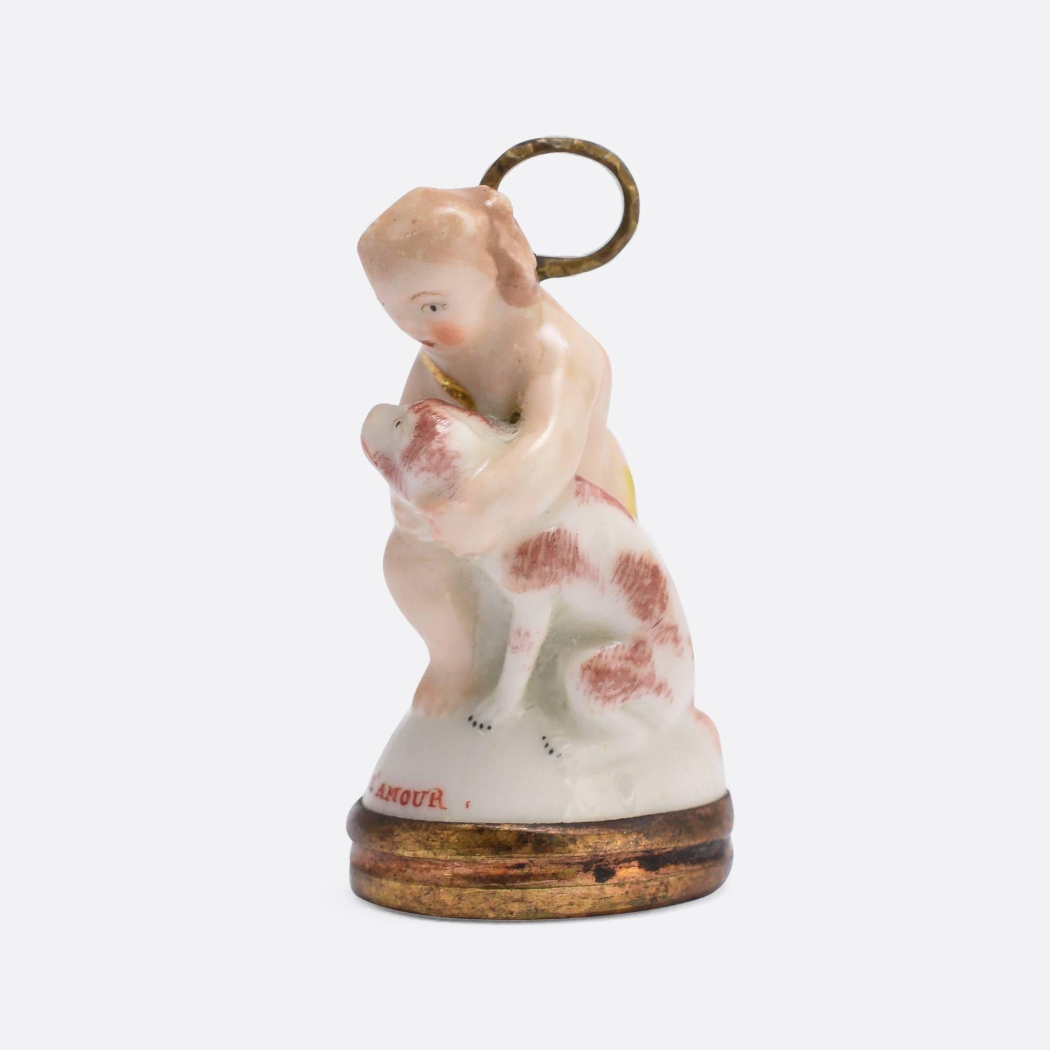An original 18th Century porcelain Derby Chelsea period fob seal. This particular piece features Cupid and a dog and displays the pale colouring typical of the Chelsea factory. The original gold bail and seal base are both present on this Georgian