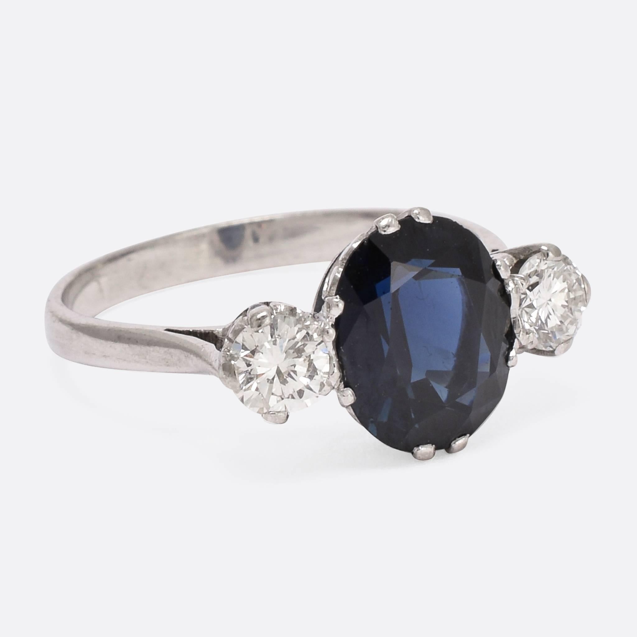 This gorgeous antique trilogy ring is set with a 2.5 carat central sapphire, flanked by two .24ct brilliant cut diamonds. Modelled in platinum, the stones are held by beautifully ornate claws, and the ring dates to c.1920. The three stones of a