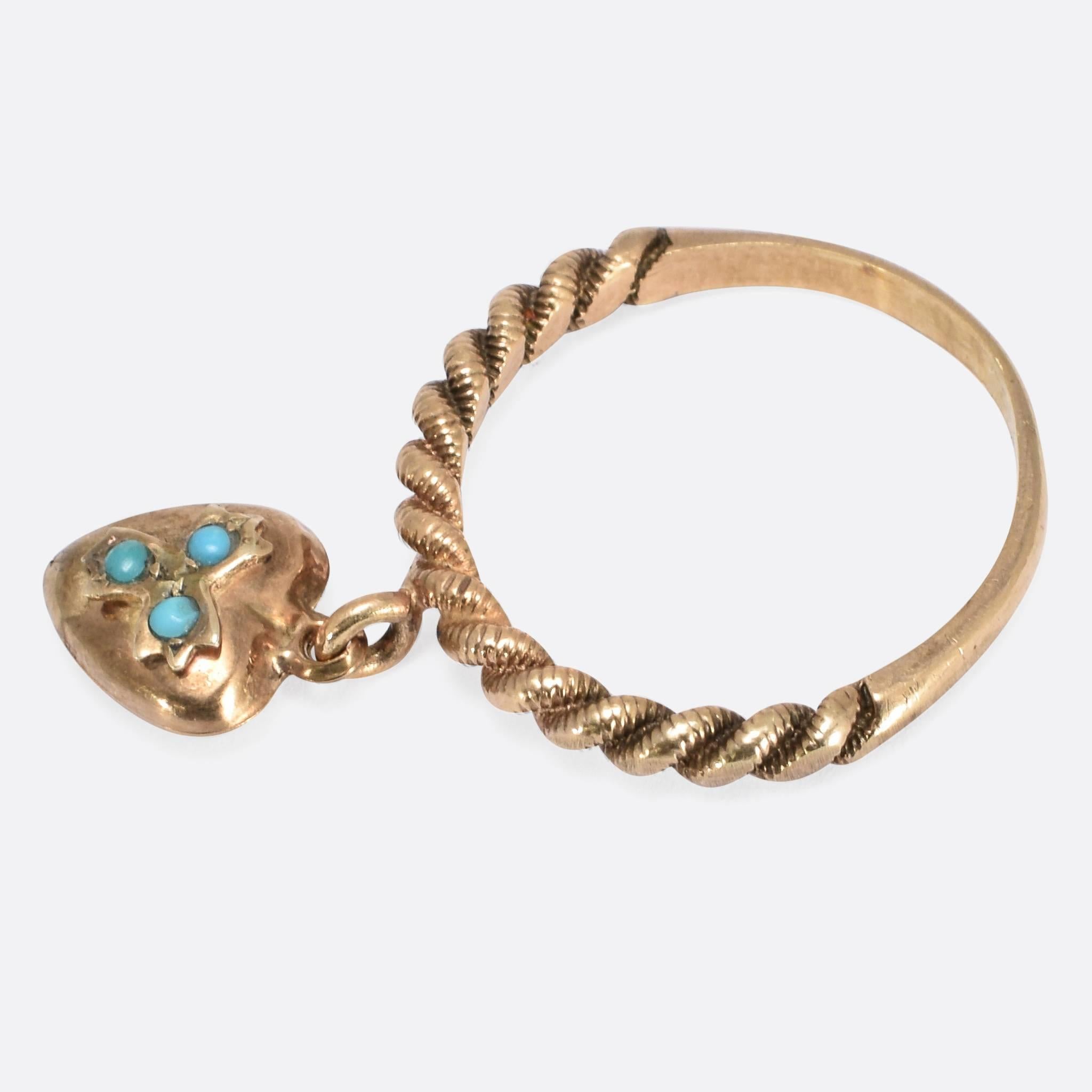 This sweet Victorian ring features a twisted design and an articulated heart drop, set with three turquoise stones. It's modelled in 9ct rose gold, and dates to c.1880. Ring Size:US: 7.5, or UK: O 1/2.