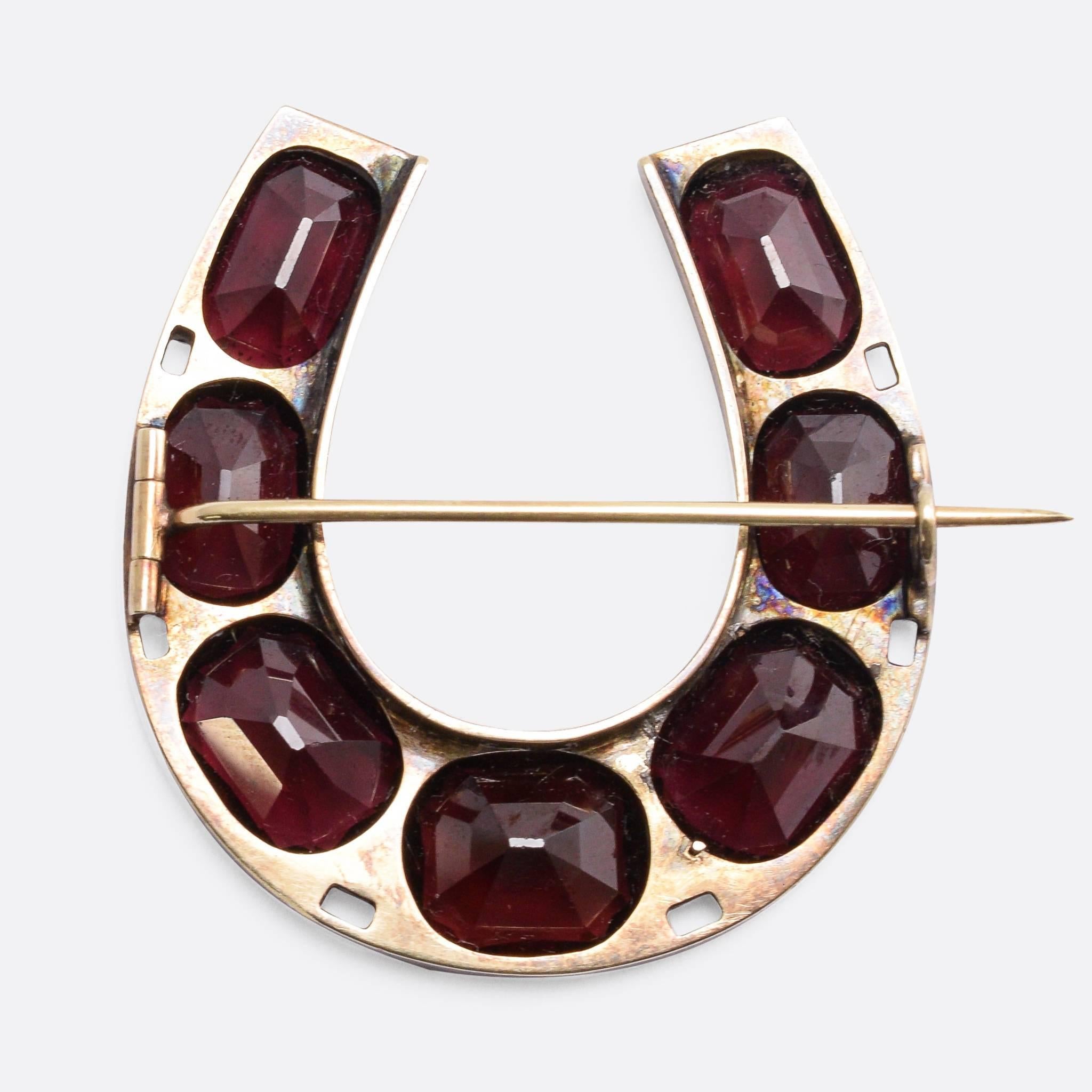 This exceptional late Victorian oversized horseshoe brooch is set with flat cut garnets, and rose cut diamonds. It measures 3.8cm across - a bold statement piece, with gorgeous deep-red stones. Modelled in 15k gold.