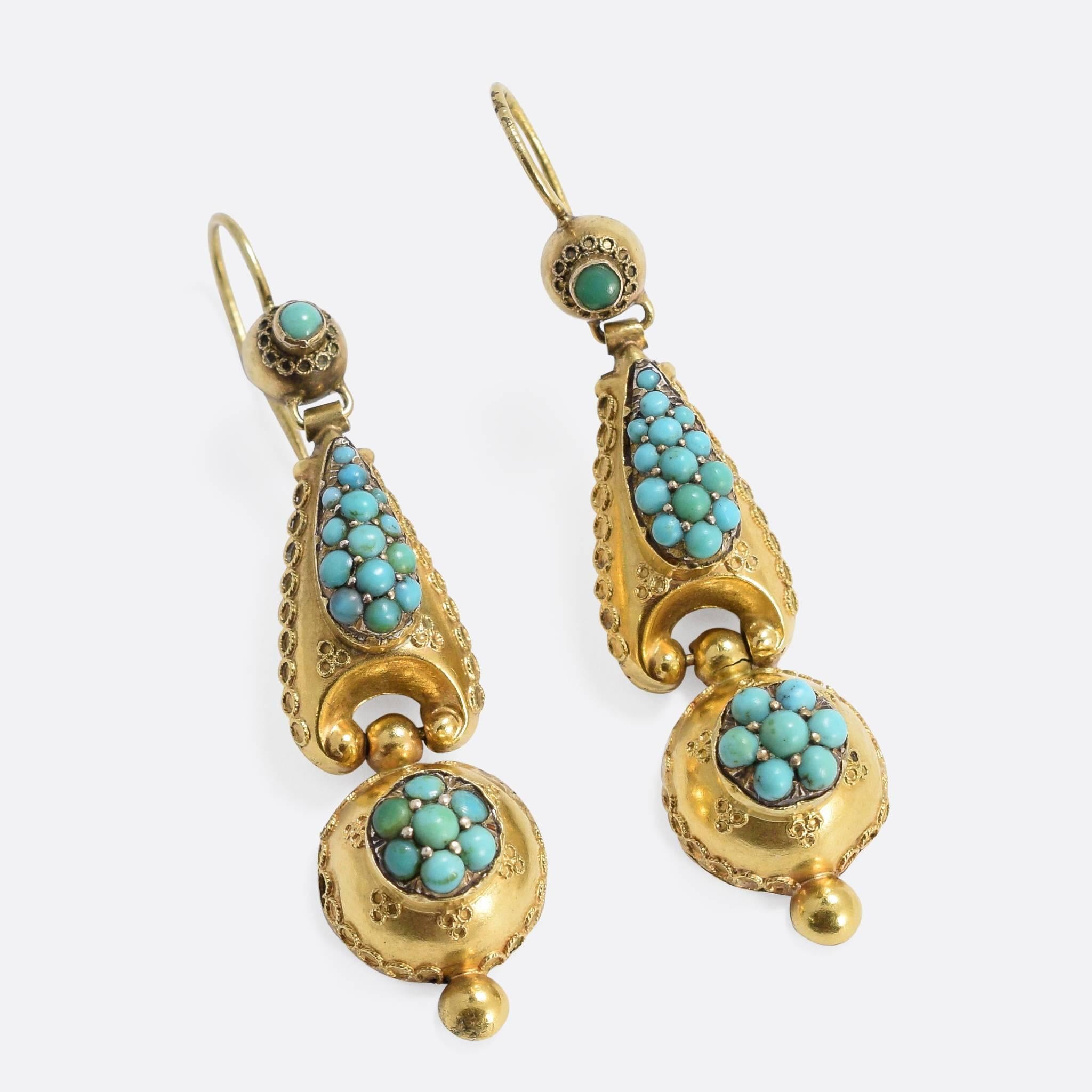 A beautiful pair of antique long drop earrings, modelled in 15k gold with applied rope work detailing in the Etruscan style. Two clusters adorn the main body and the drop respectively. The Etruscan Revival movement was influenced by jewellery found