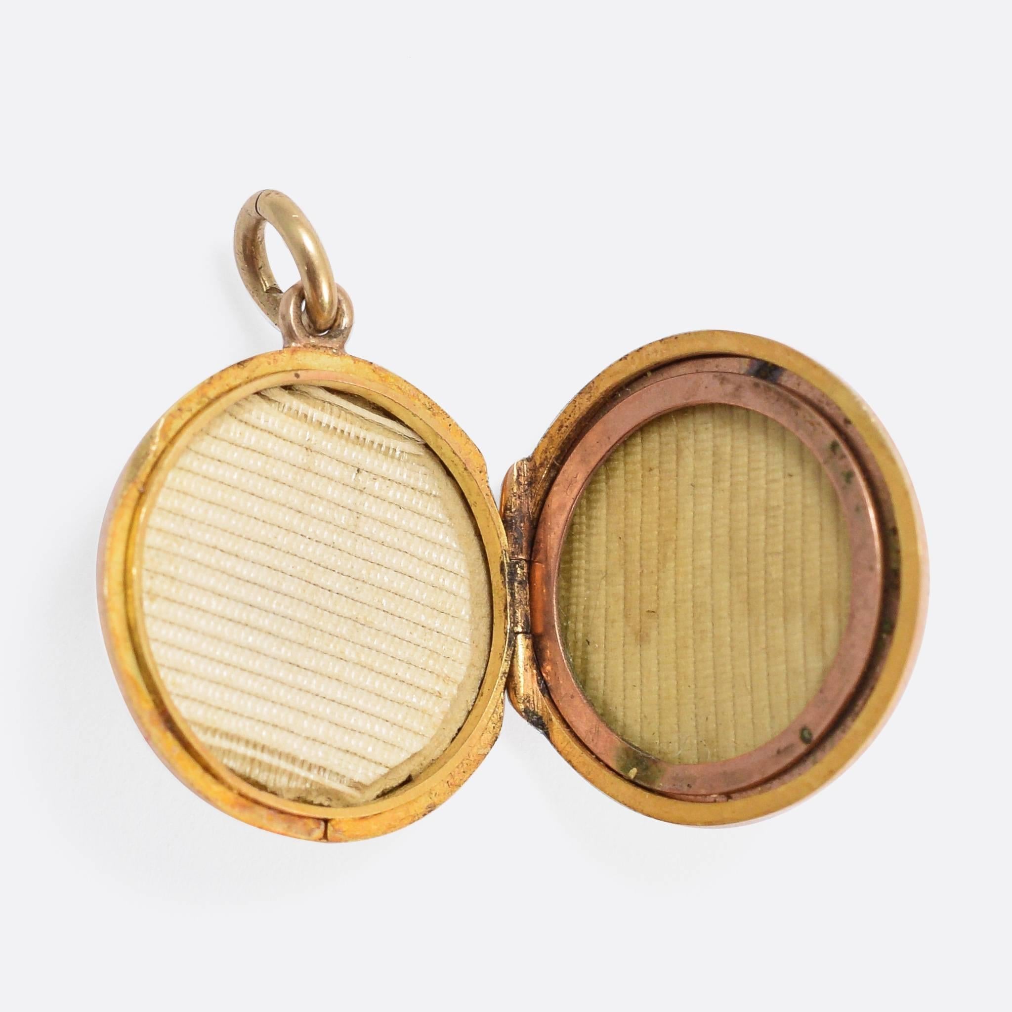 An attractive antique round locket, modelled in 15k gold throughout. The front is set with two old cut diamonds and a vivid blue lab-grown sapphire. The piece opens, hinged on one side, with space inside for a small photo or memento.