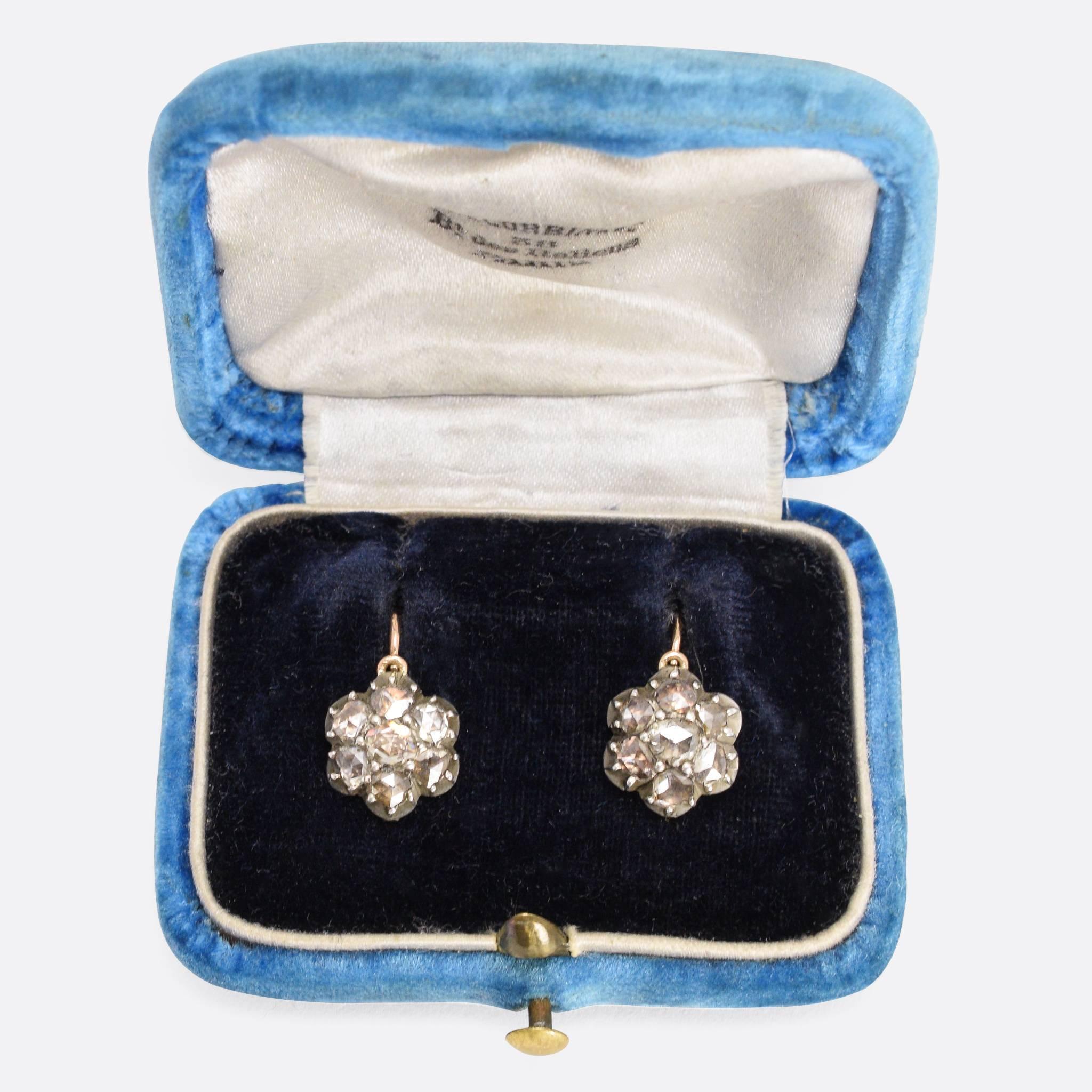 These adorable antique cluster earrings are set with foil-backed rose cut diamonds, arranged in flower formation. The heads are a good size, measuring  10mm across, and the stones set in silver as was typical at this time. It is likely that the 18k