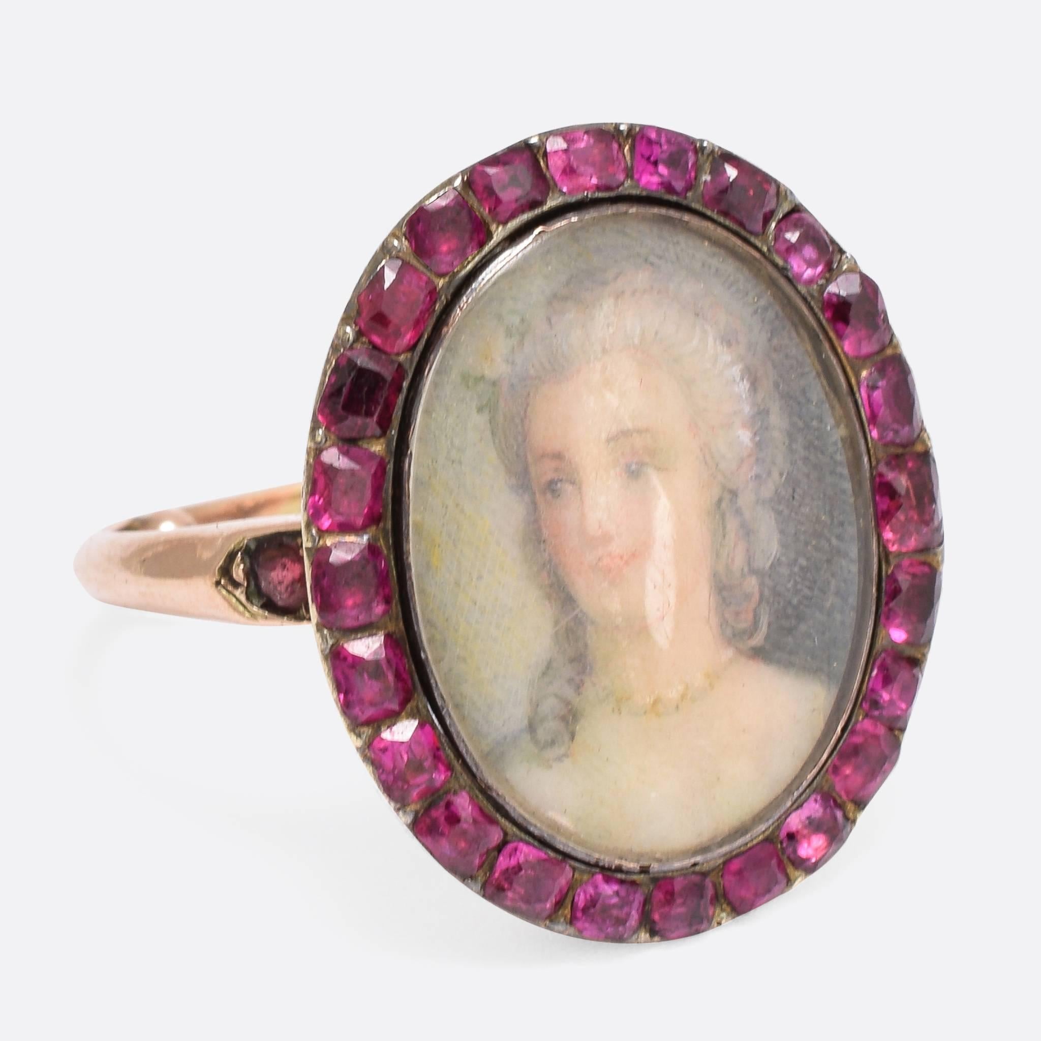 This stunning antique ring features a halo of rubies, around a finely painted miniature portrait of a lady (wearing a rivière necklace, no less!). Modelled in 15k gold, the shoulders feature further ruby accents and the band has had sizing beads