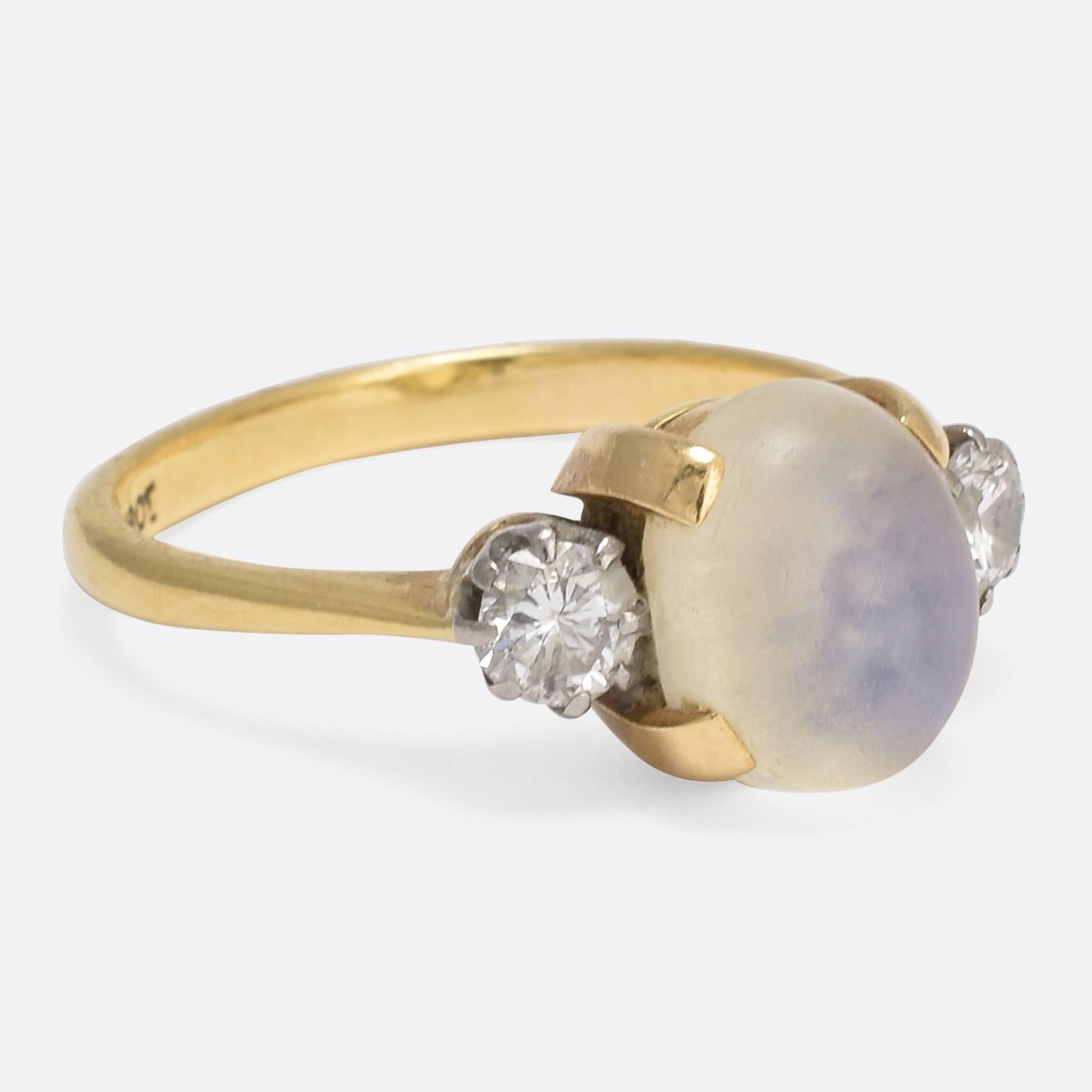 This superb 1920s ring is set with a central blue moonstone, flanked by two brilliant cut diamonds. Modelled in 18k yellow gold, the diamonds are set is white gold claw mounts to create a lovely two-tone effect. The moonstone displays particularly