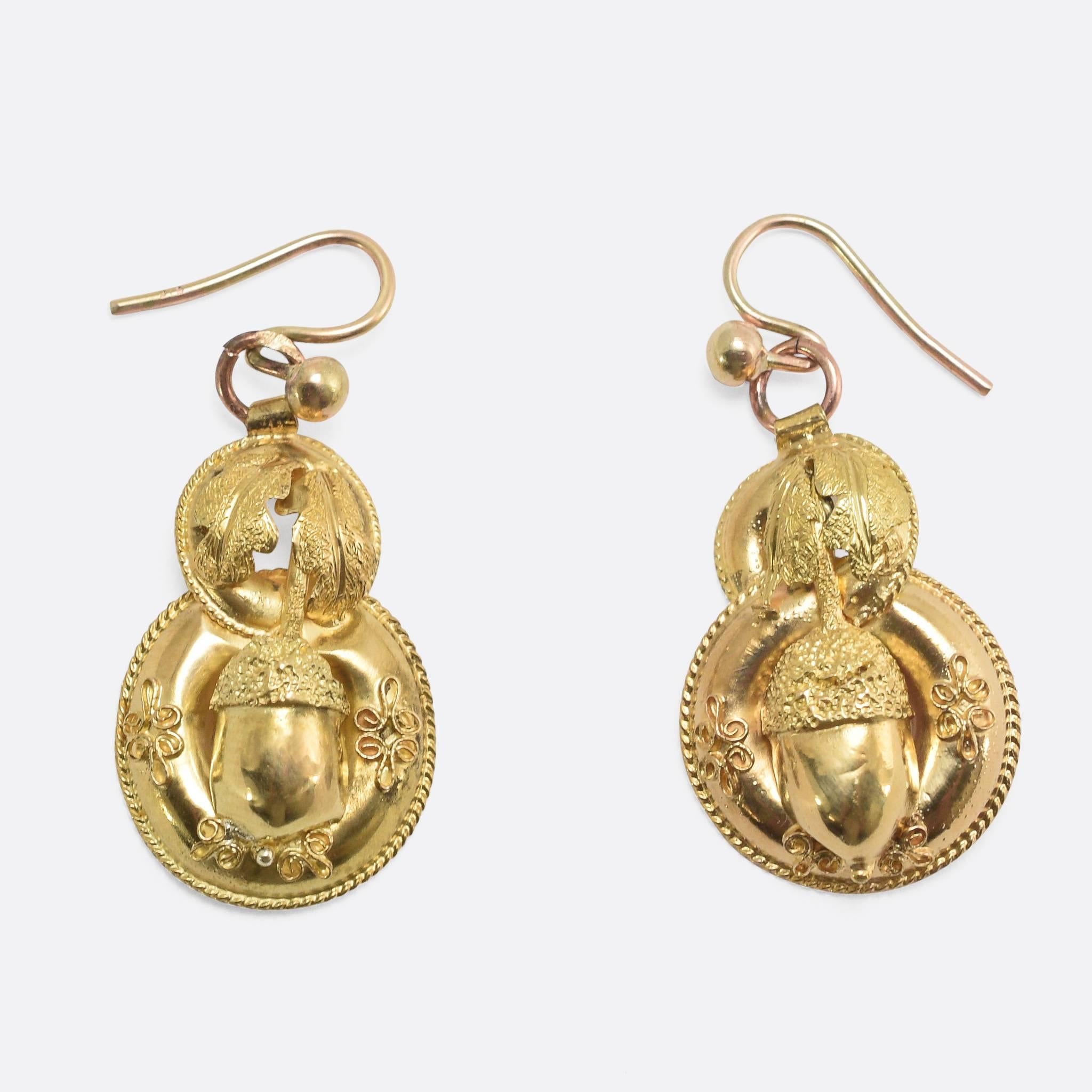 This beautiful pair of earrings is modelled in 15k yellow gold. The lightweight design is in the Etruscan Revival style, with applied rope-work detailing and an acorn and oak leaves on each. An attractive pair, in remarkably good condition