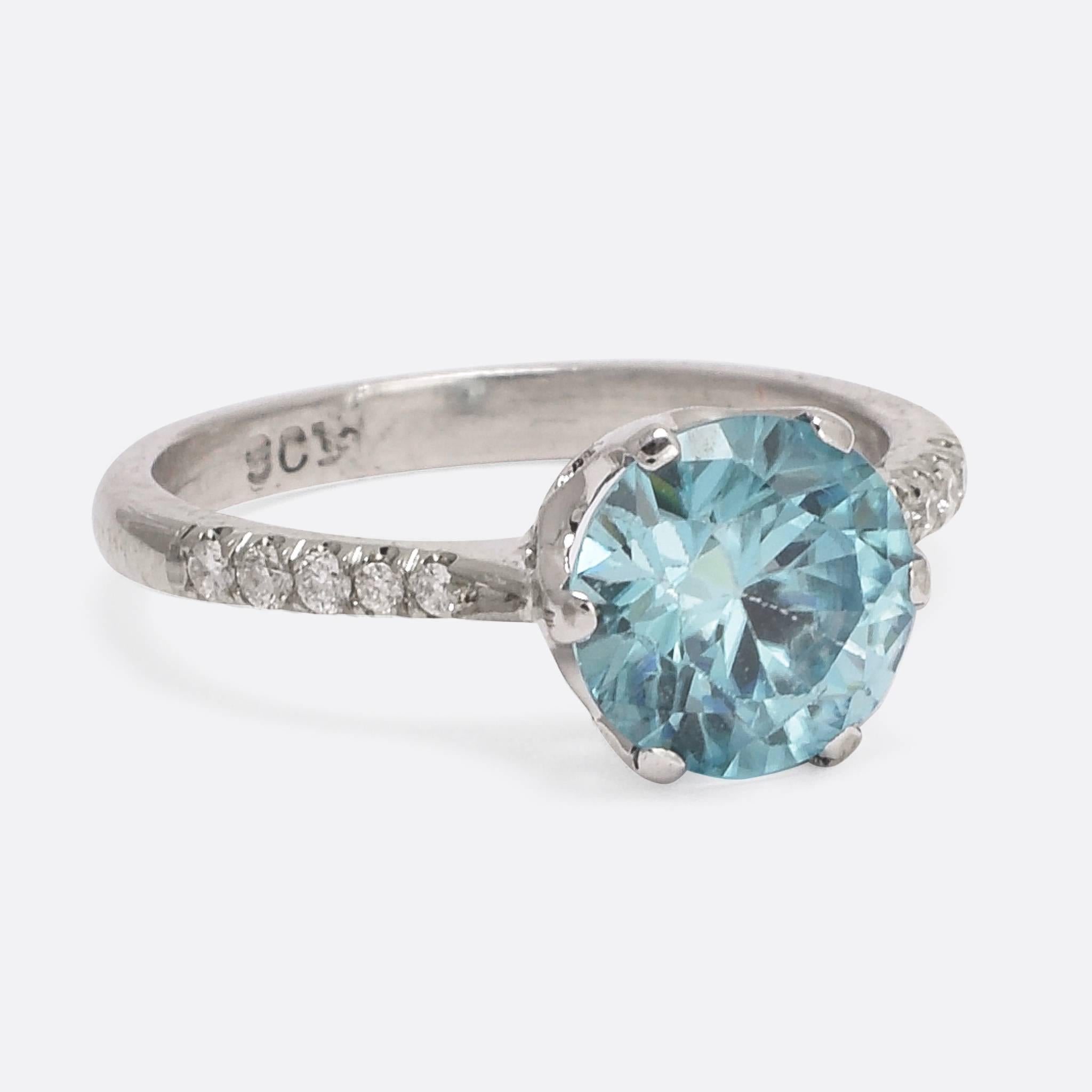 A cool early Art Deco era zircon and diamond solitaire ring. The principal stone is stunning: a lucid blue colour with bright flash and fire, it weighs just under 1.68. Modelled in white gold and platinum, it dates to the early 1920s, with elegant