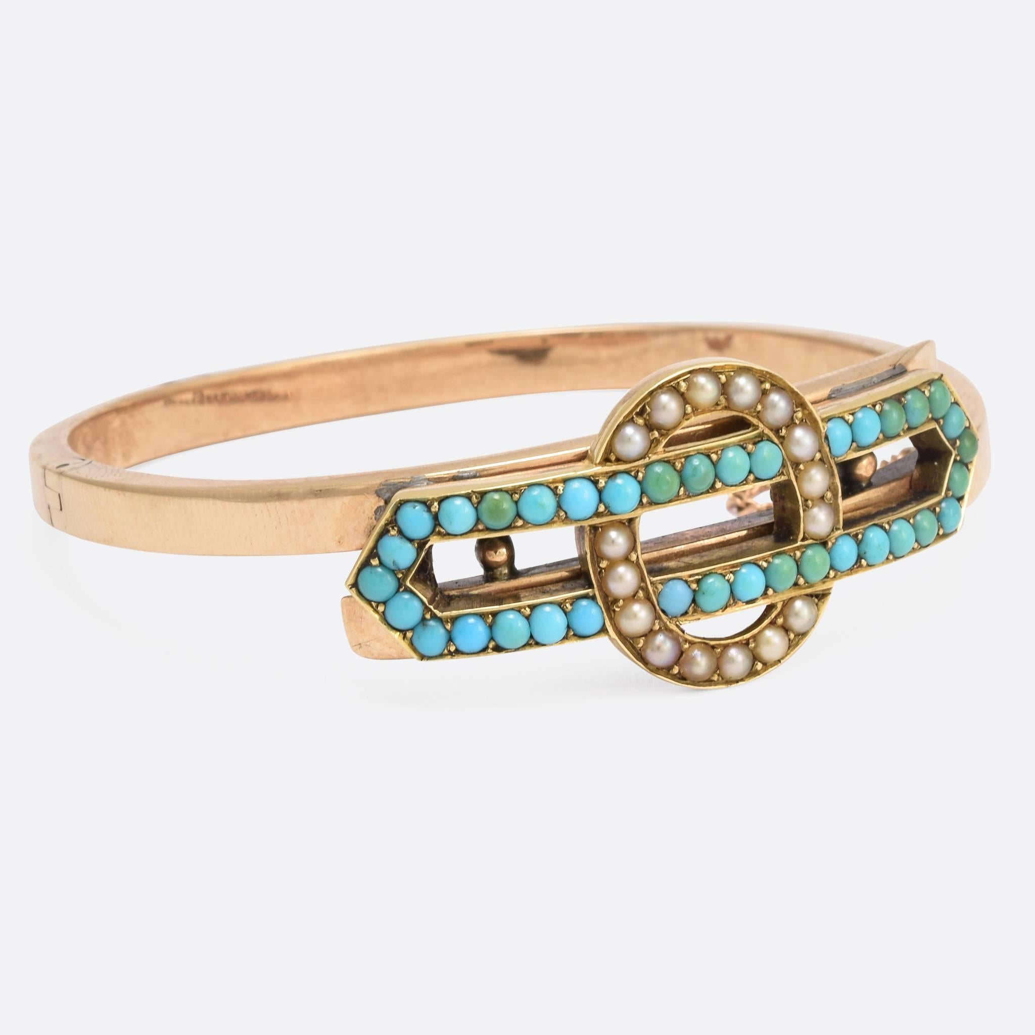 A stylish antique hinged bangle dating to the late Victorian period. The head is modelled as a stylised Infinity Knot, and set with turquoise cabochons and split pearls. Crafted from 15k gold throughout, this lovely piece is very typical of the era.