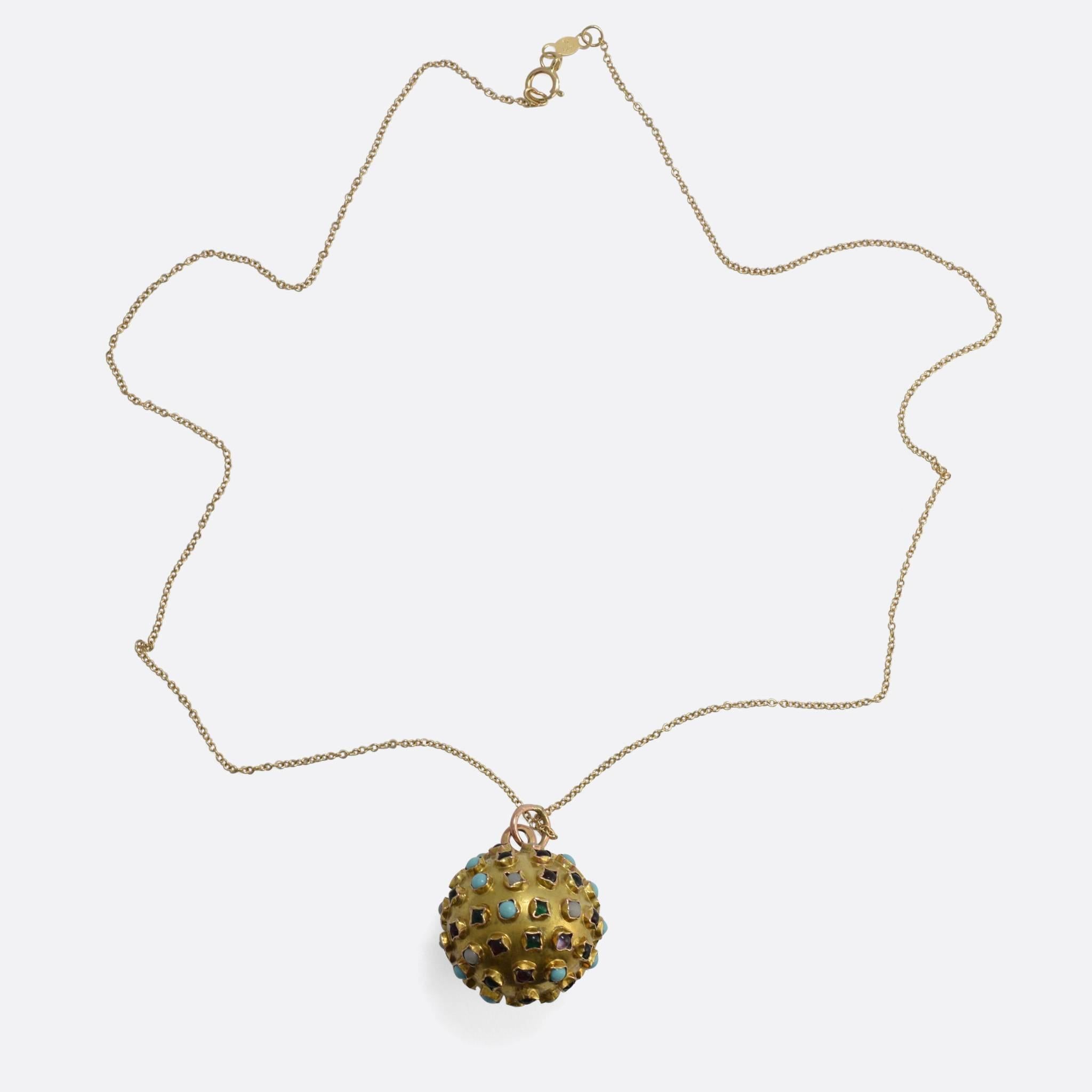 This striking orb pendant dates to the 1960s, and holds a strong Space Race vibe. It's modelled in 18k gold and set with a variety of coloured gemstones, including: ruby, emerald, amethyst, garnet, turquoise and opal. It's a good large size, and