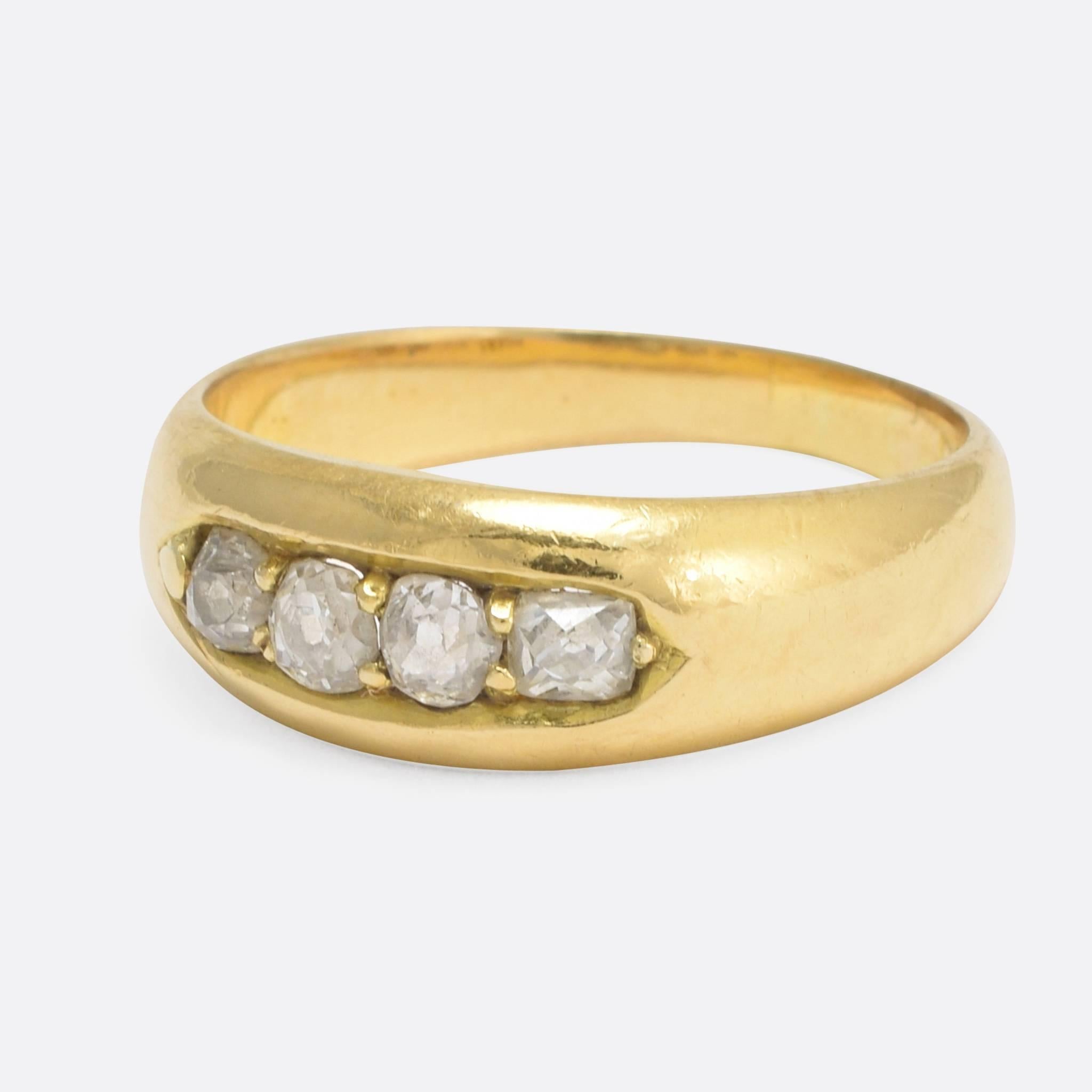 A lovely antique gypsy ring set with four diamonds: three old European cuts, and one old mine cut - the total carat weight is approximately .40ct. The plain band is modelled in 18k yellow gold, that has developed a beautiful antique patina over the