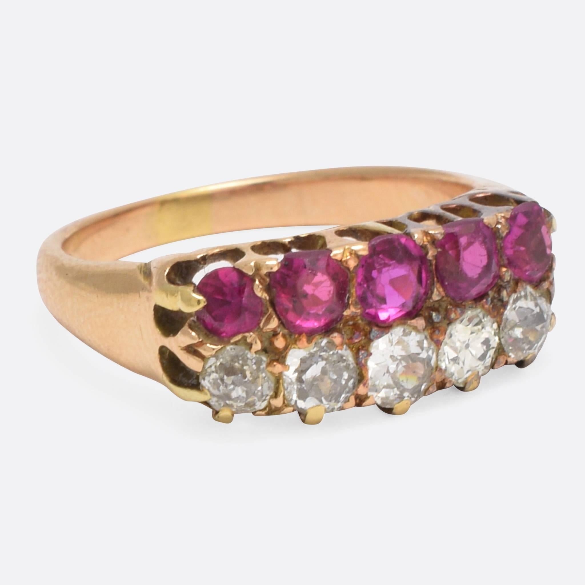 This splendid antique ring is set with two rows of gems: one ruby, one diamond. Modelled in 18k gold, the stones are set in elongated claw mounts with spaces behind that let light illuminate the stones. An elegant and timeless piece with a total