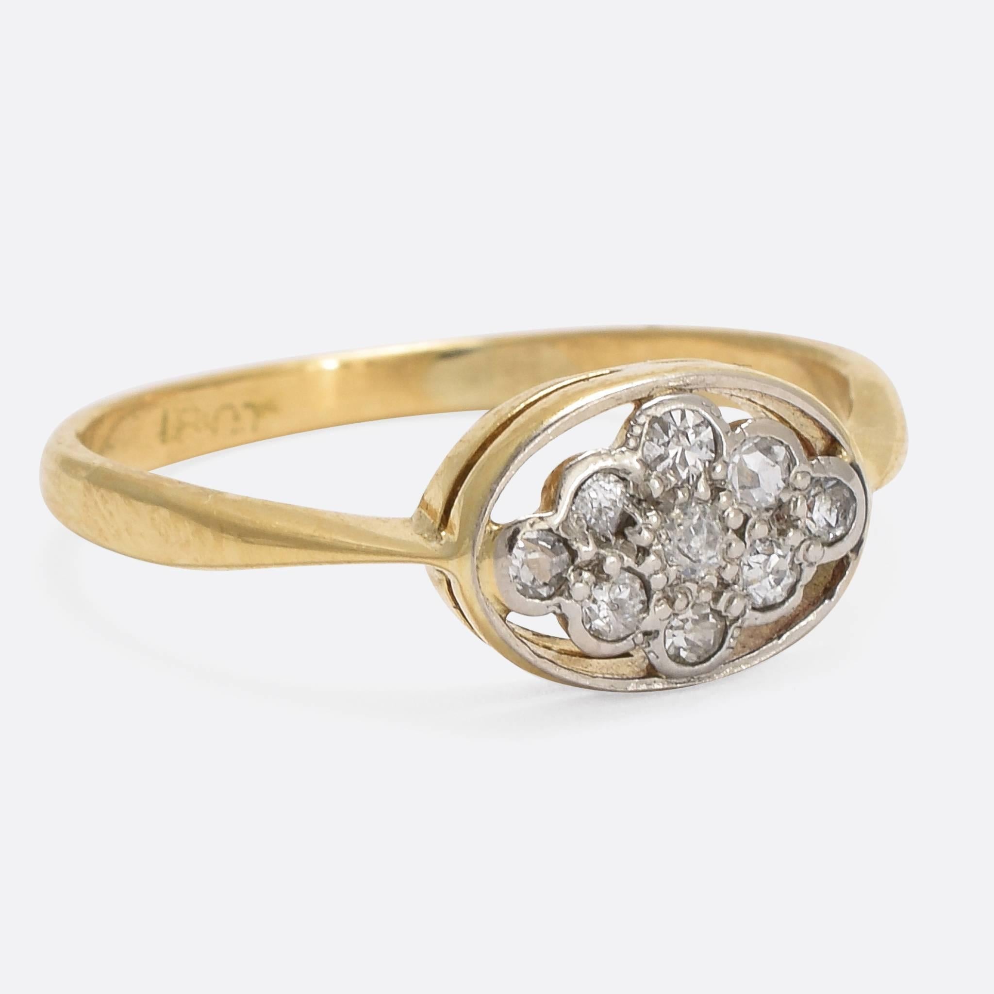 This pretty 1920s cluster ring is set with nine sparkling white diamonds, surrounded by an oval platinum halo. The delicate head is complemented by elegant pinched shoulders. Modelled in 18k yellow gold with platinum settings. Ring Size: 6.