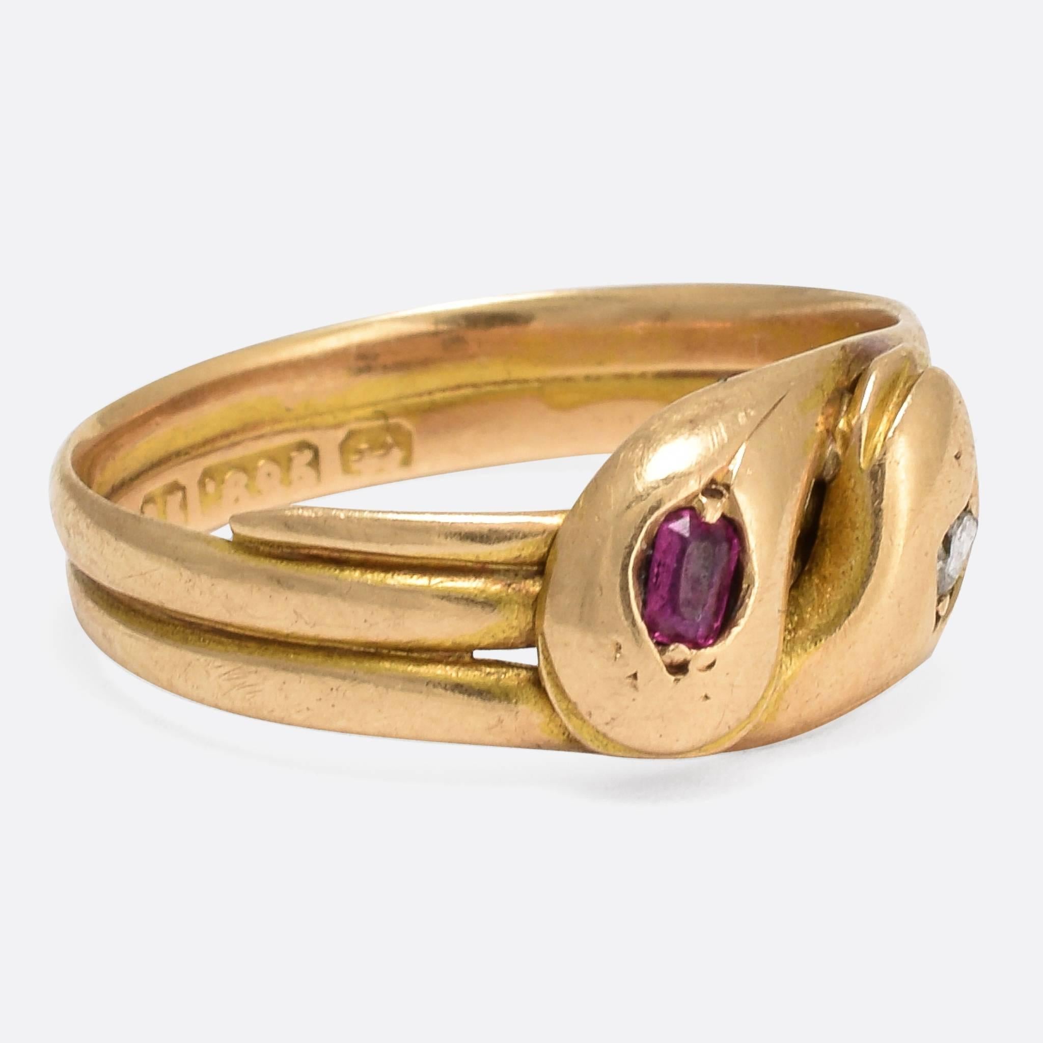 This classic coiled double snake ring is modelled in 15k yellow gold, with clear Chester hallmarks for the year 1882. Each head is set with a gemstone - one ruby and one rose cut diamond - and they rest together in a kind of snake hug. A pretty,