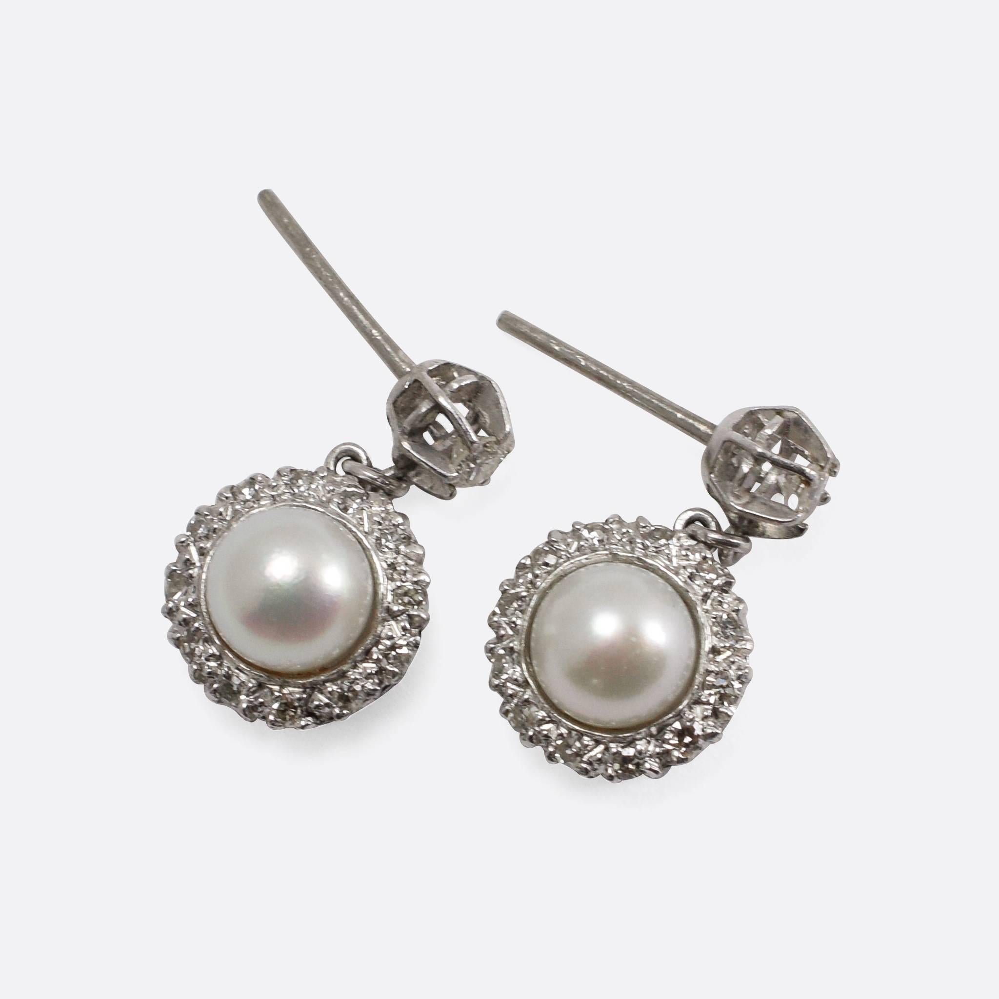 The prettiest pair of stud earrings, with a pearl and diamond cluster drop - sitting beneath a single claw-set diamond. They date to the 1930s, and would make a wonderful wedding accessory. Modelled in platinum throughout.