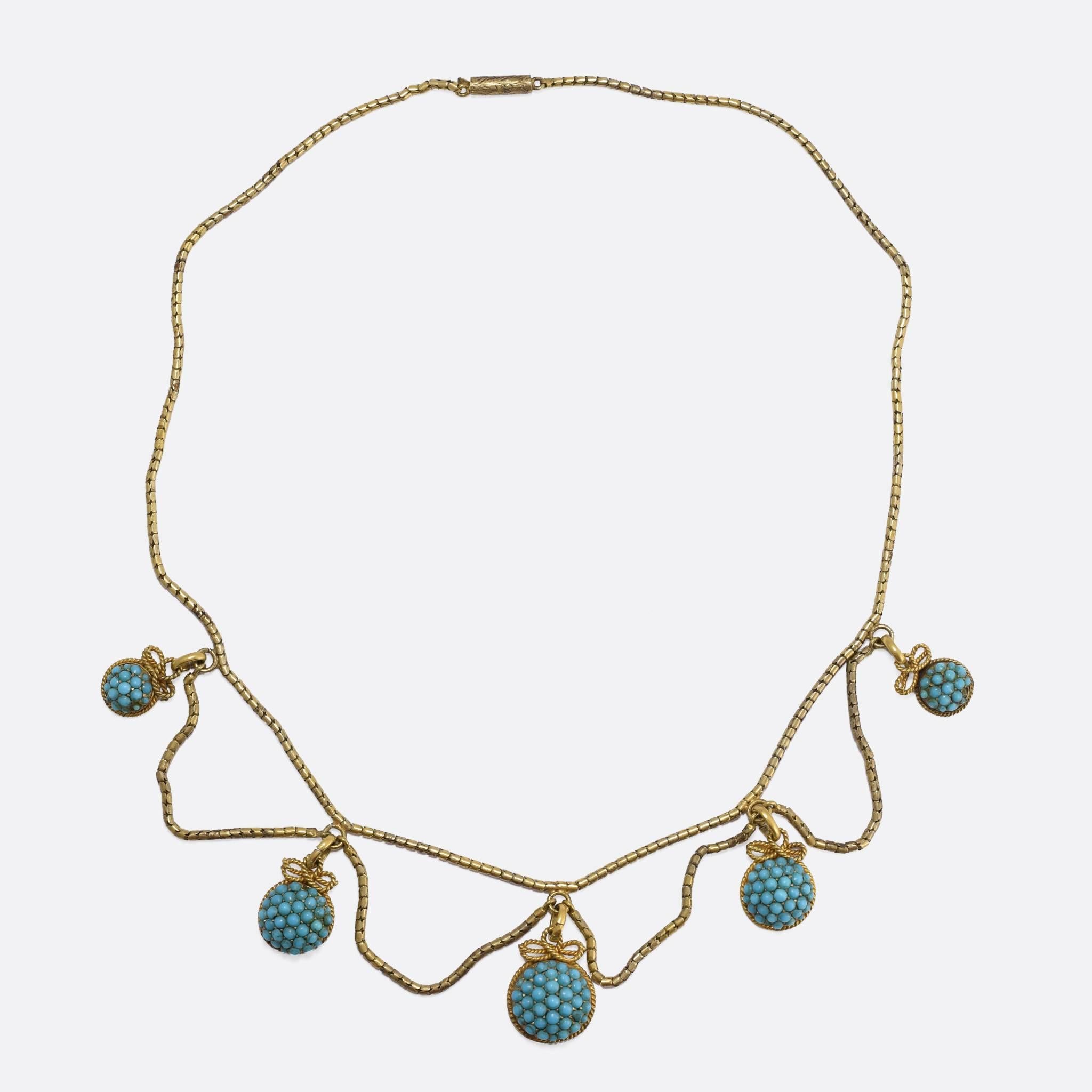 This elegant Victorian necklace is made in the Etruscan Revival style. It features five graduated drops, each pavé set with tiny turquoise cabochons, and finished in applied ropework detail. The Etruscan Revivalist movement began in the mid 19th