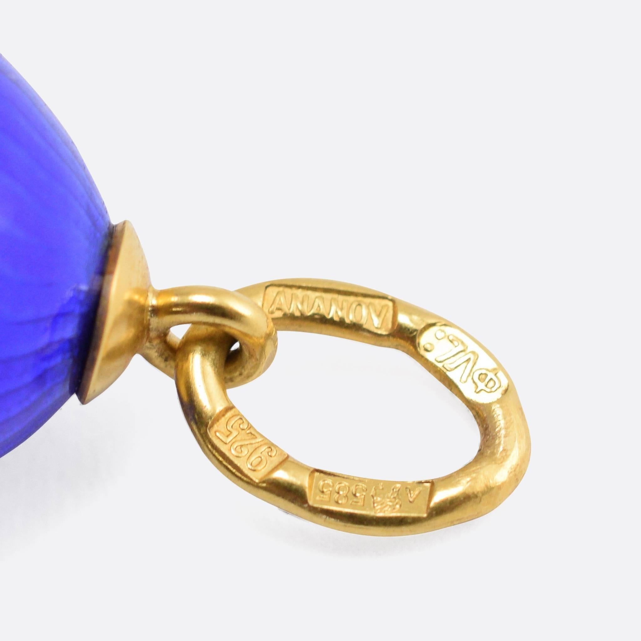 This beautiful Miniature Egg Pendant is by the celebrated jewellery maker Andrey Ananov. The egg is modelled in Sterling silver, with 14k gold fittings, and finished in fine deep blue guilloché enamel. A gold band around the middle is features a bow