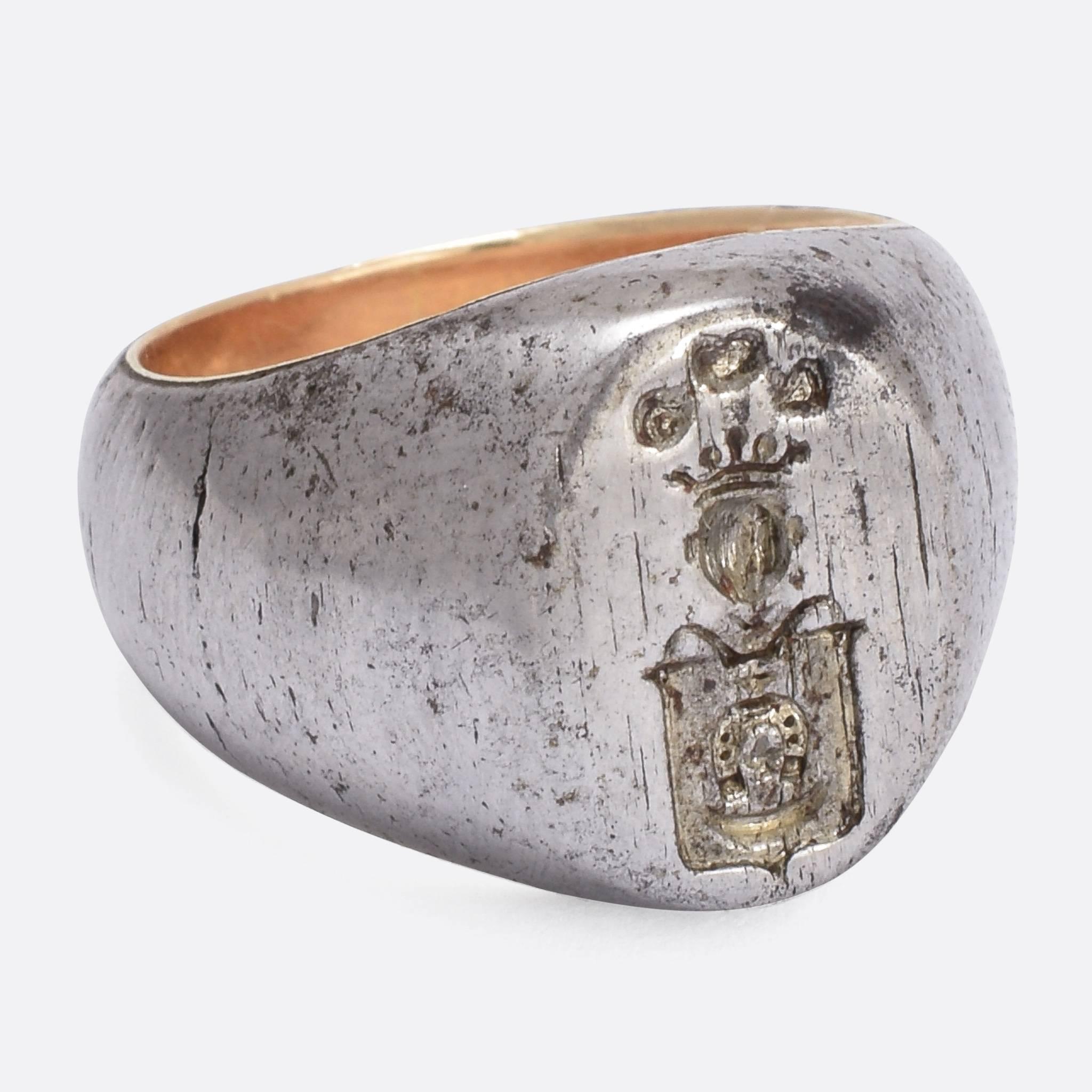 This remarkable antique signet ring is, quite unusually, made from steel. It's a good size and weight, with a heraldic coat of arms on the face. The intaglio carving depicts shield with horseshoe  crest, under a crowned knight's helm. It's a great