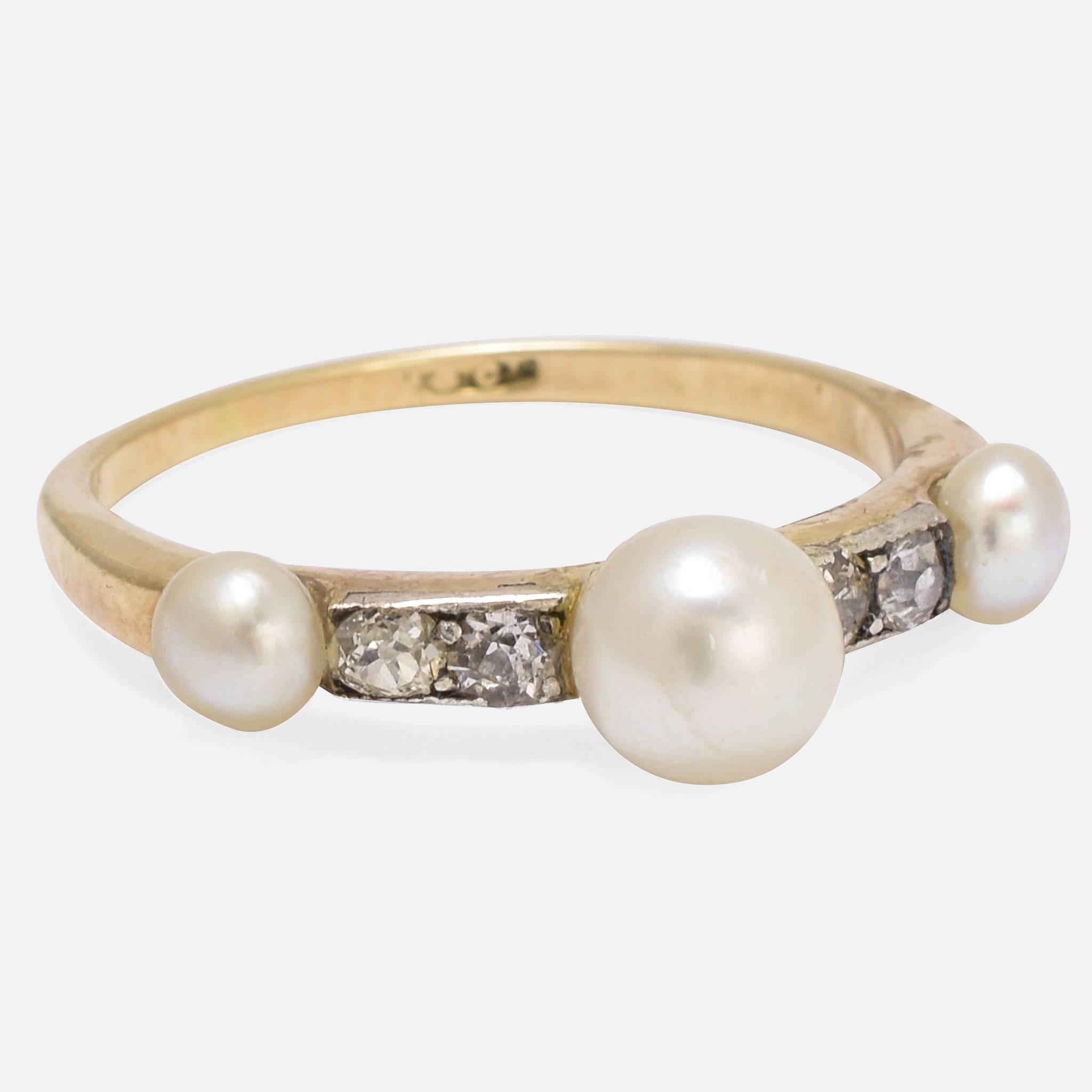 This stylish Edwardian era ring is set with pearls and old cut diamonds. It's modelled in 18k gold and platinum, and is ideal for stacking. Ring size: 6.25.