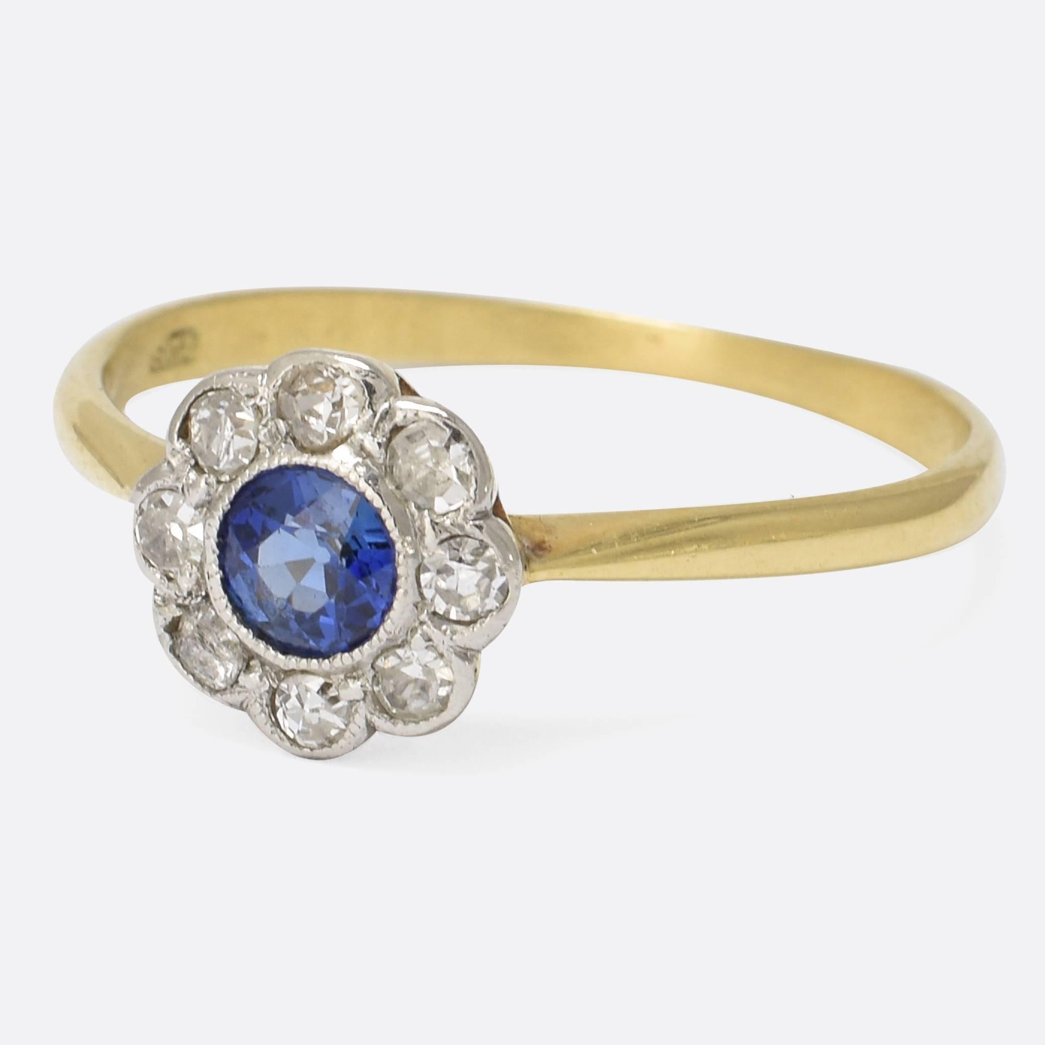 A pretty sapphire and diamond daisy ring dating to the Edwardian era, c.1910. It’s modelled in 18k gold with elegant pinched shoulders and platinum settings – a particularly well formed head with lovely petals and fine millegrain detail. Ring Size: