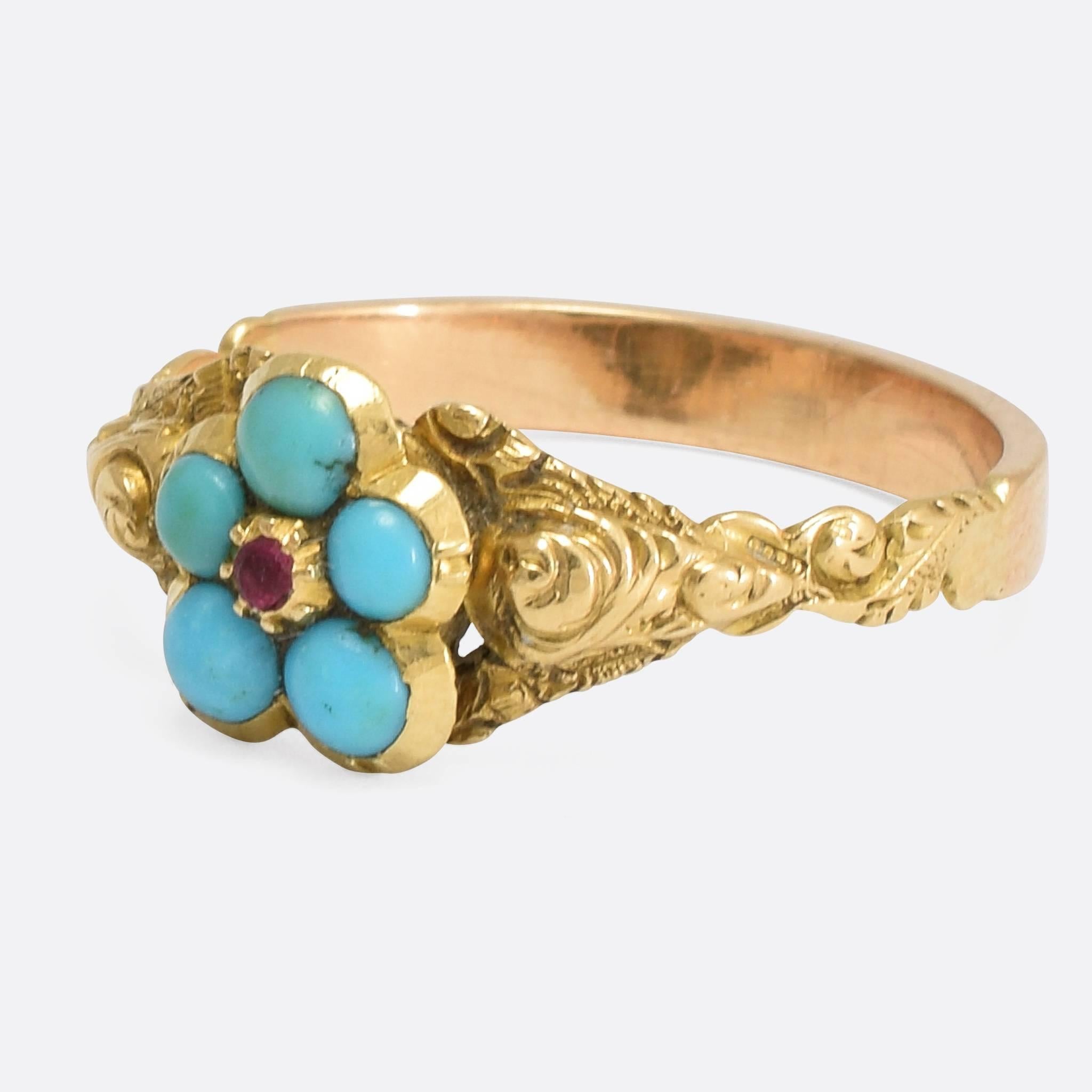 A gorgeous antique pansy ring with exquisite hand-chased shoulder detailing. The head is modelled as a pansy flower - set with five turquoise cabochons around a central ruby - while the band is modelled in 15k yellow gold. 
The name pansy is derived