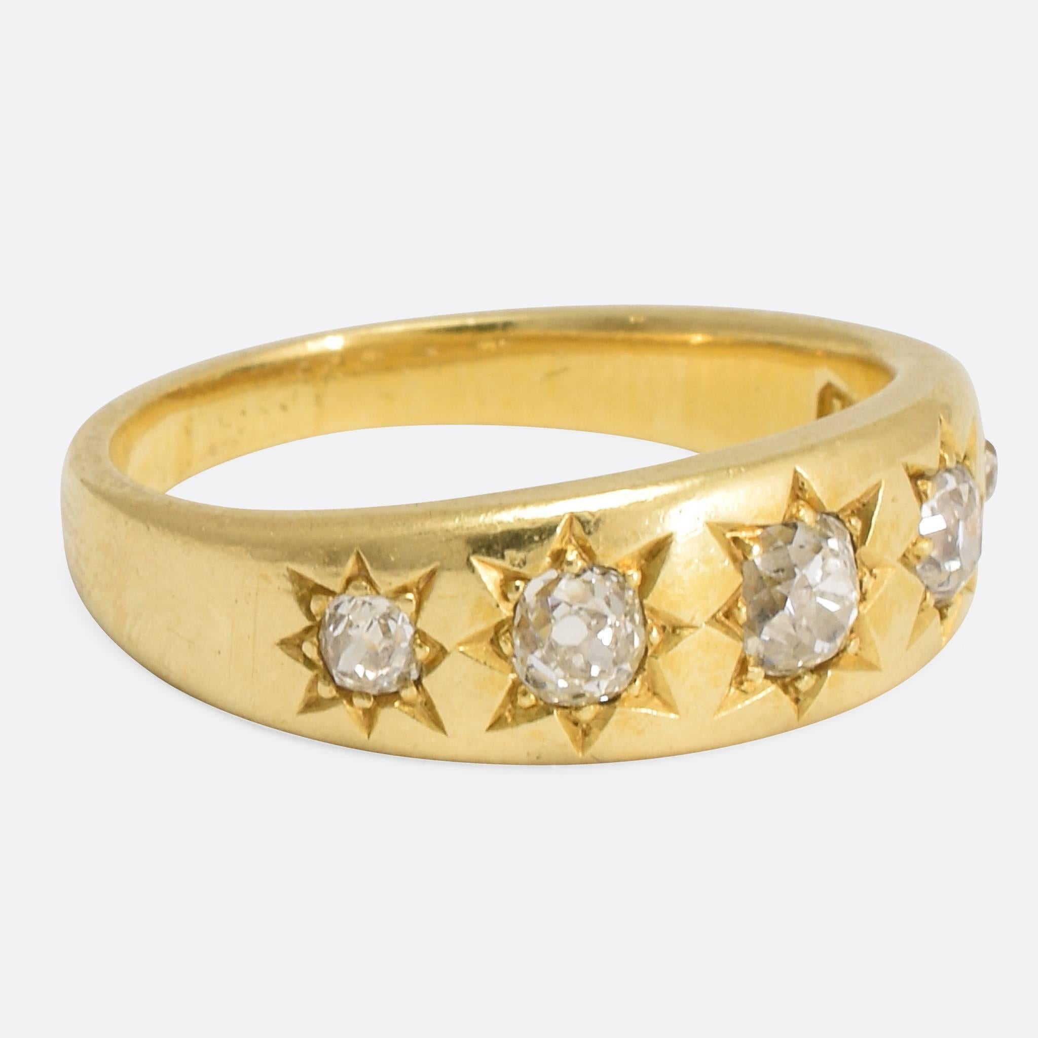 A wonderful antique band ring, set with five cushion cut diamonds mounted in attractive eight-point star settings. Modelled in 18k yellow gold, the ring dates to the late 19th Century and the total diamond weight is 0.74ct. Ring size: 7.25.