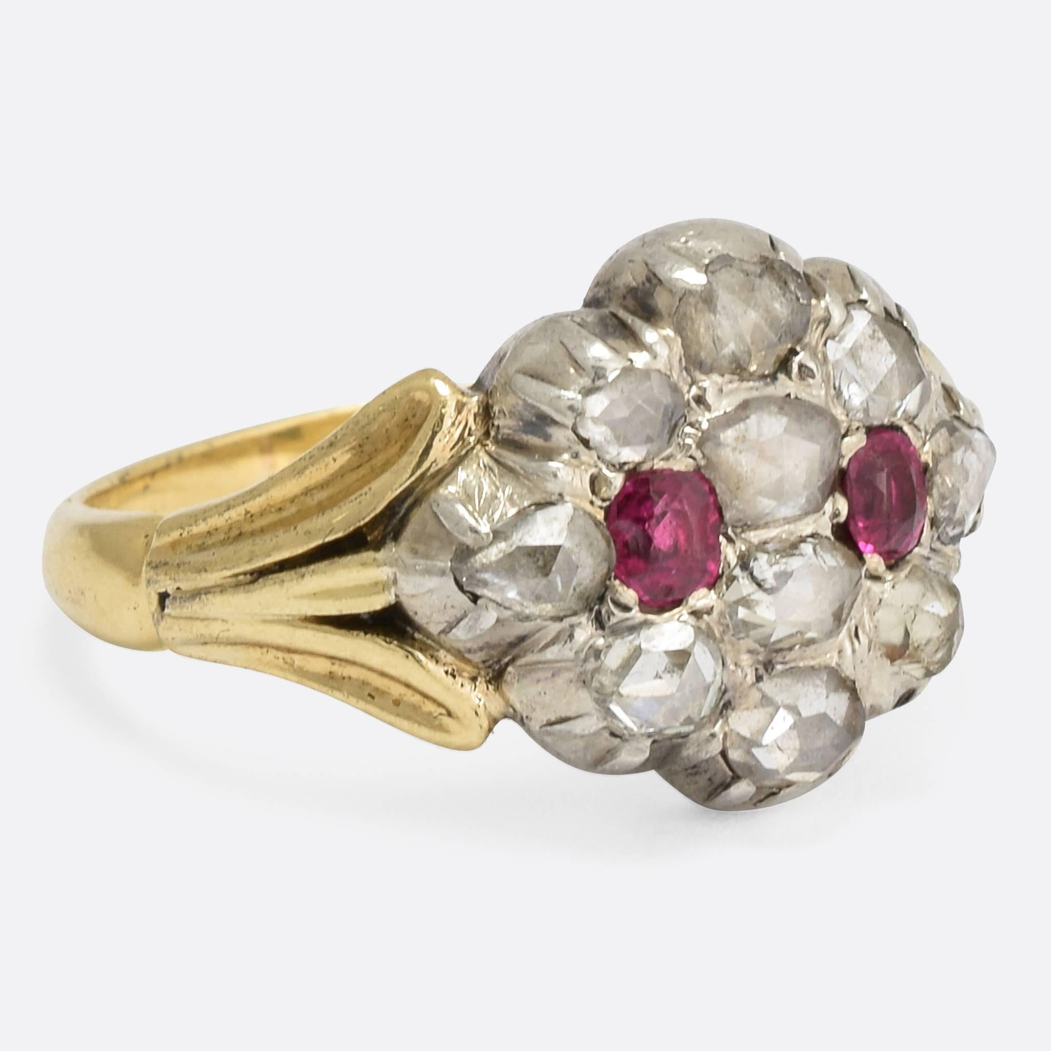 A cool Georgian cluster ring, set with rose cut diamonds and rubies in foil-backed settings. It's modelled in 15k yellow gold, with silver settings typical of the period, and attractive trifurcated shoulders. The stones are bright and full of