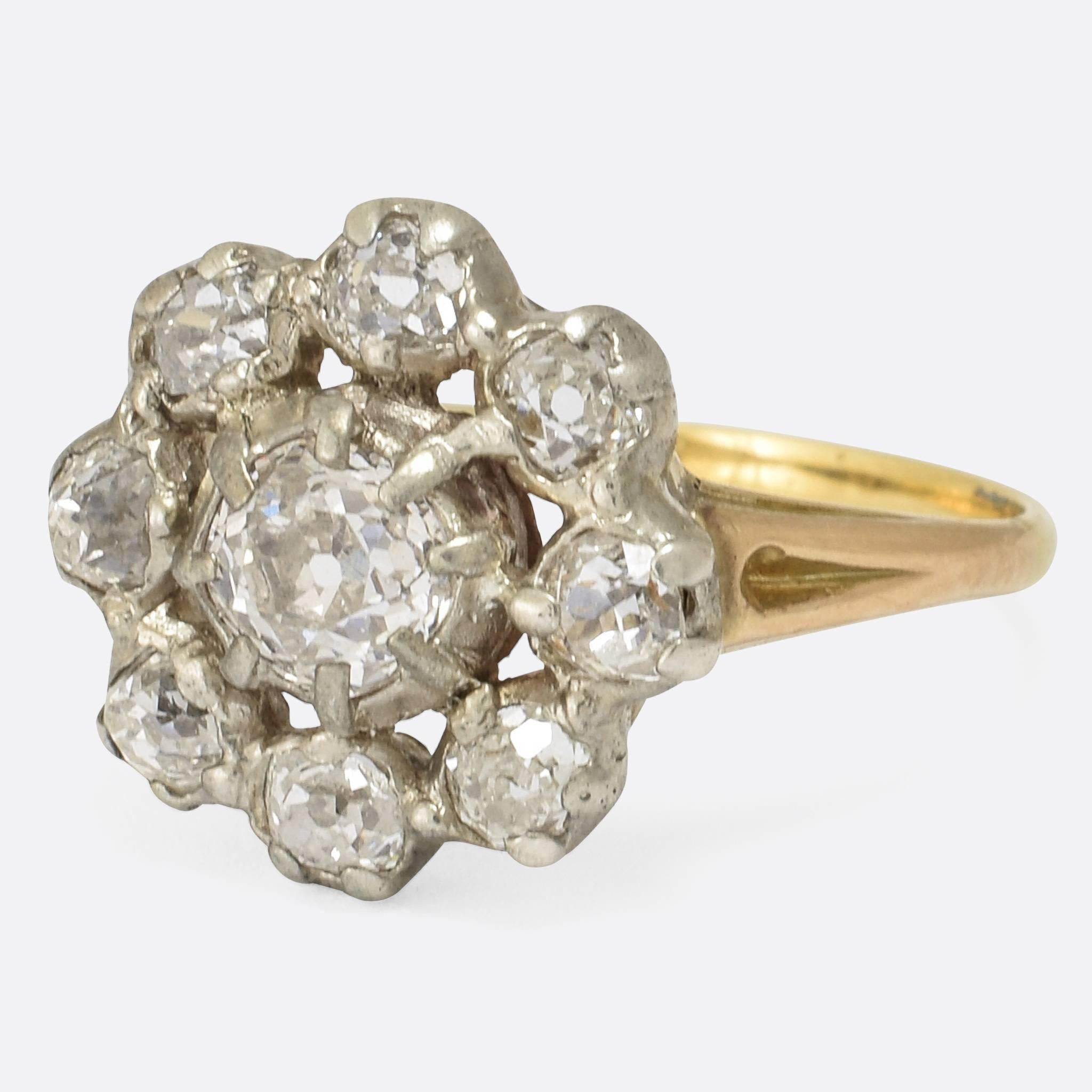 This stunning antique cluster ring dates to the late Georgian period. It's set with a carat and a half of bright old mine cut diamonds (8x .12ct stones surrounding a central .55ct stone). The diamonds remain in their original silver settings - very