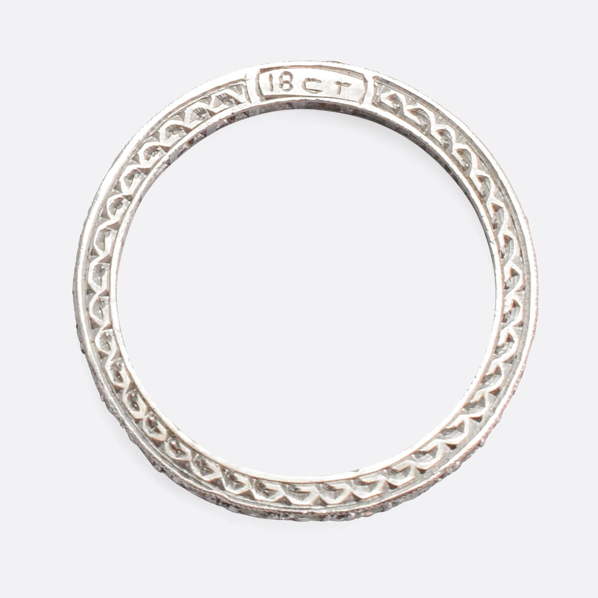 An exceptional 1920s Eternity Ring, modelled in 18k white gold and fully set with diamonds. The detail to the sides and settings is beautiful, with hand chased patterns and miellgrain edges. It's set with 26 sparkling eight-cut stones, very typical