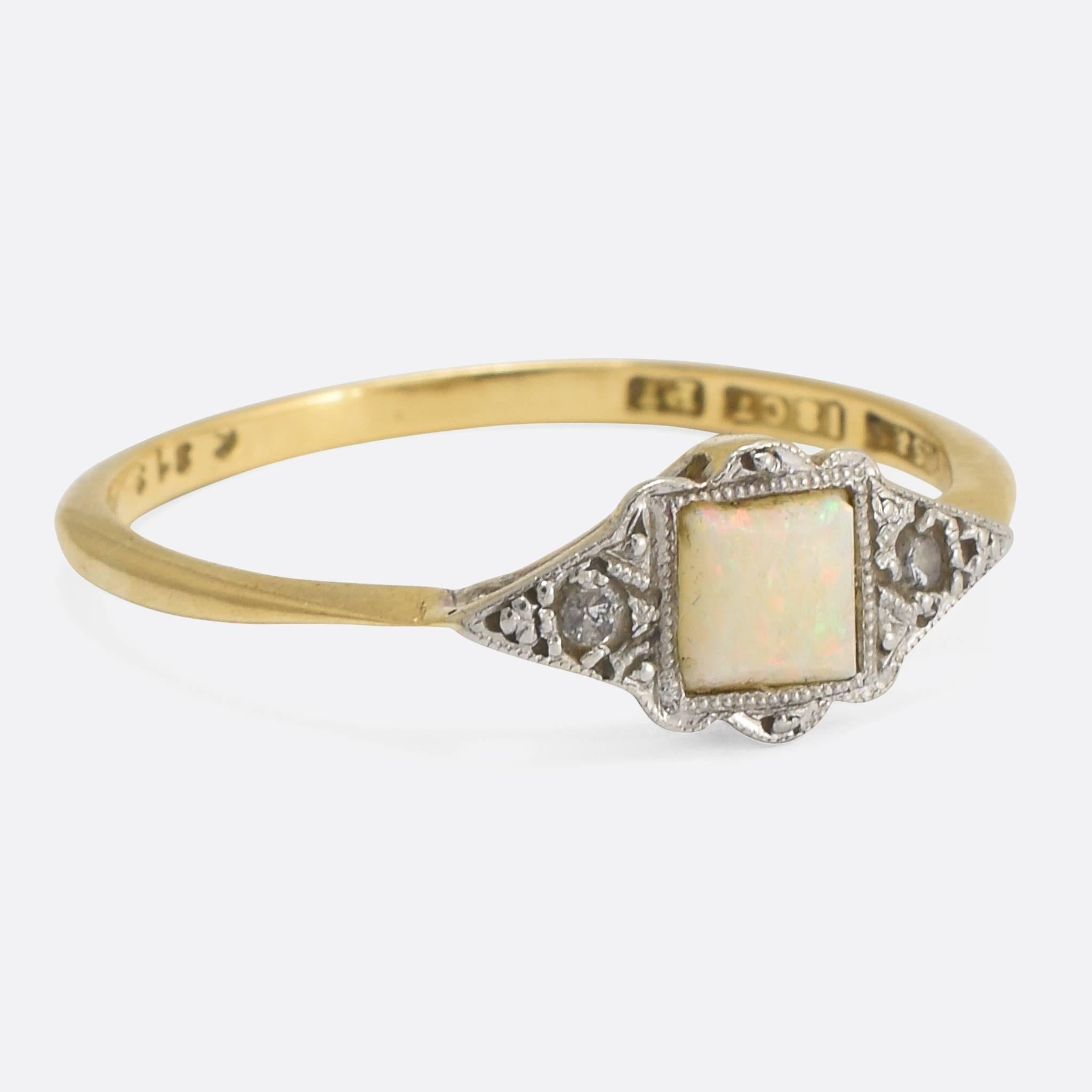A classic Art Deco era small-scale cocktail ring, set with a square opal cabochon and two single cut diamonds. The head is modelled in platinum, with fine millegrain patternation and elegant pinched shoulders. The band is modelled in 18k yellow