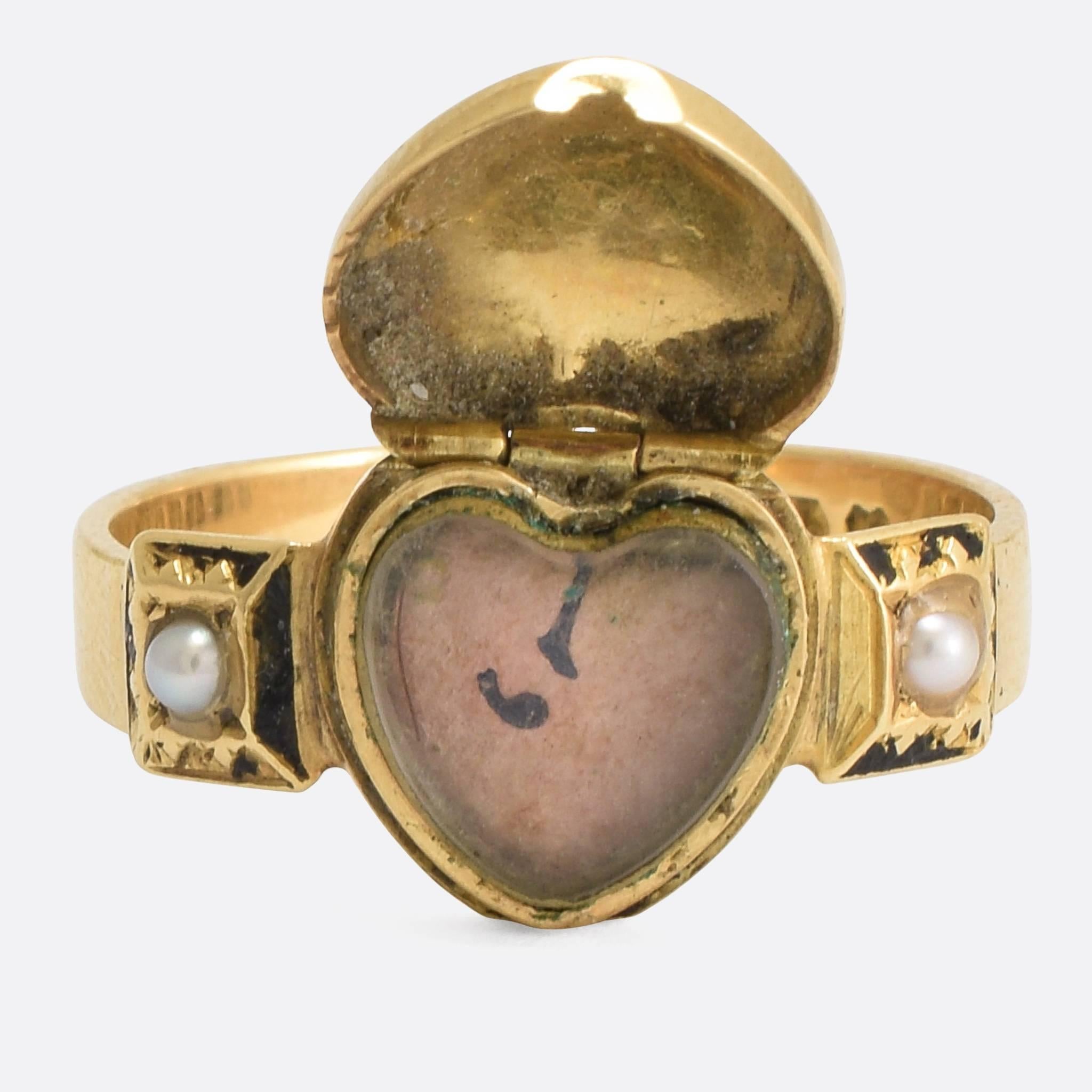 A cool Victorian mourning ring, the head modelled as a heart with hinged top allowing the front to open up revealing a glass locket compartment. The front of the heart features a Forget-Me-Not flower, set with diamonds, and the remnants of the black