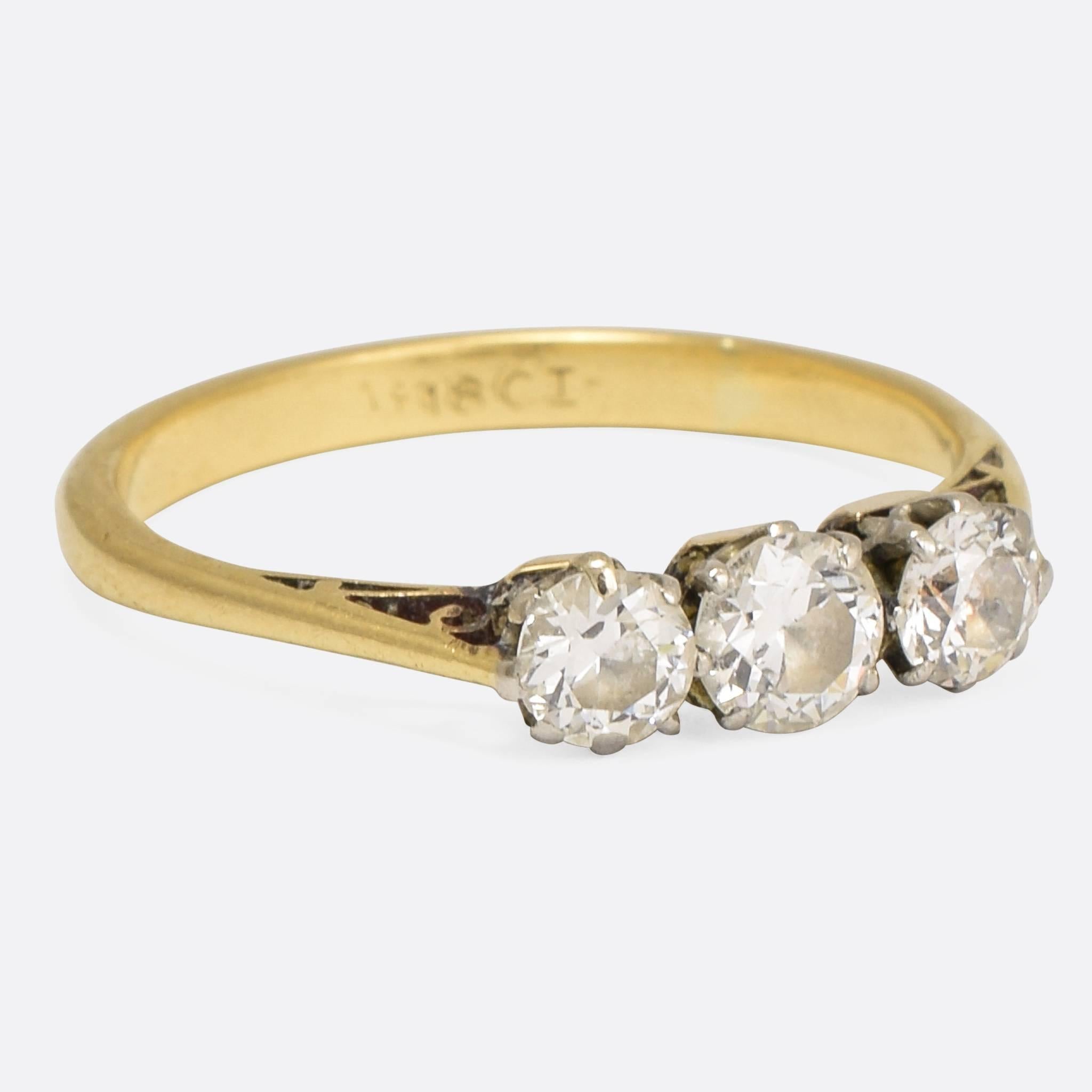 A sweet three stone Old-European cut Diamond engagement ring modelled in 18k yellow gold with platinum settings. Total Diamond weight: 60pts. VS/SI Clarity, G/H Colour. Ring size: 6.5.