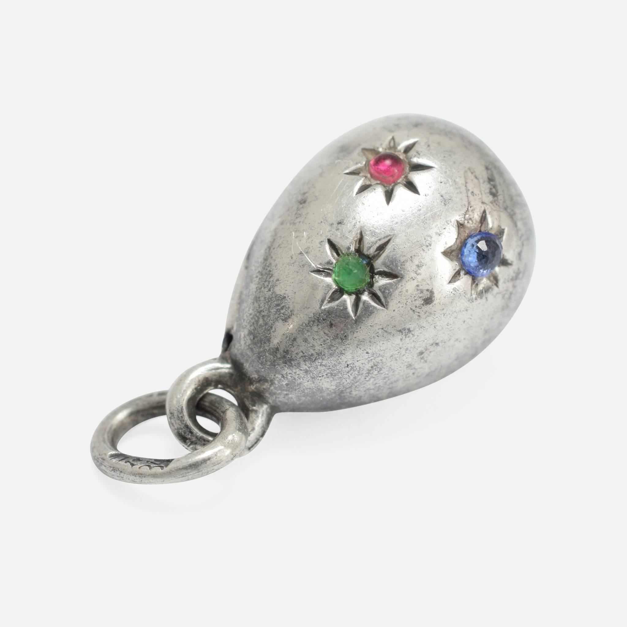 A turn of the last century Russian miniature egg pendant, modelled in silver, the bolt ring is marked with the 84 zolotnik, the main body of the egg is set with a cabochon Ruby, Emerald and Sapphire. 