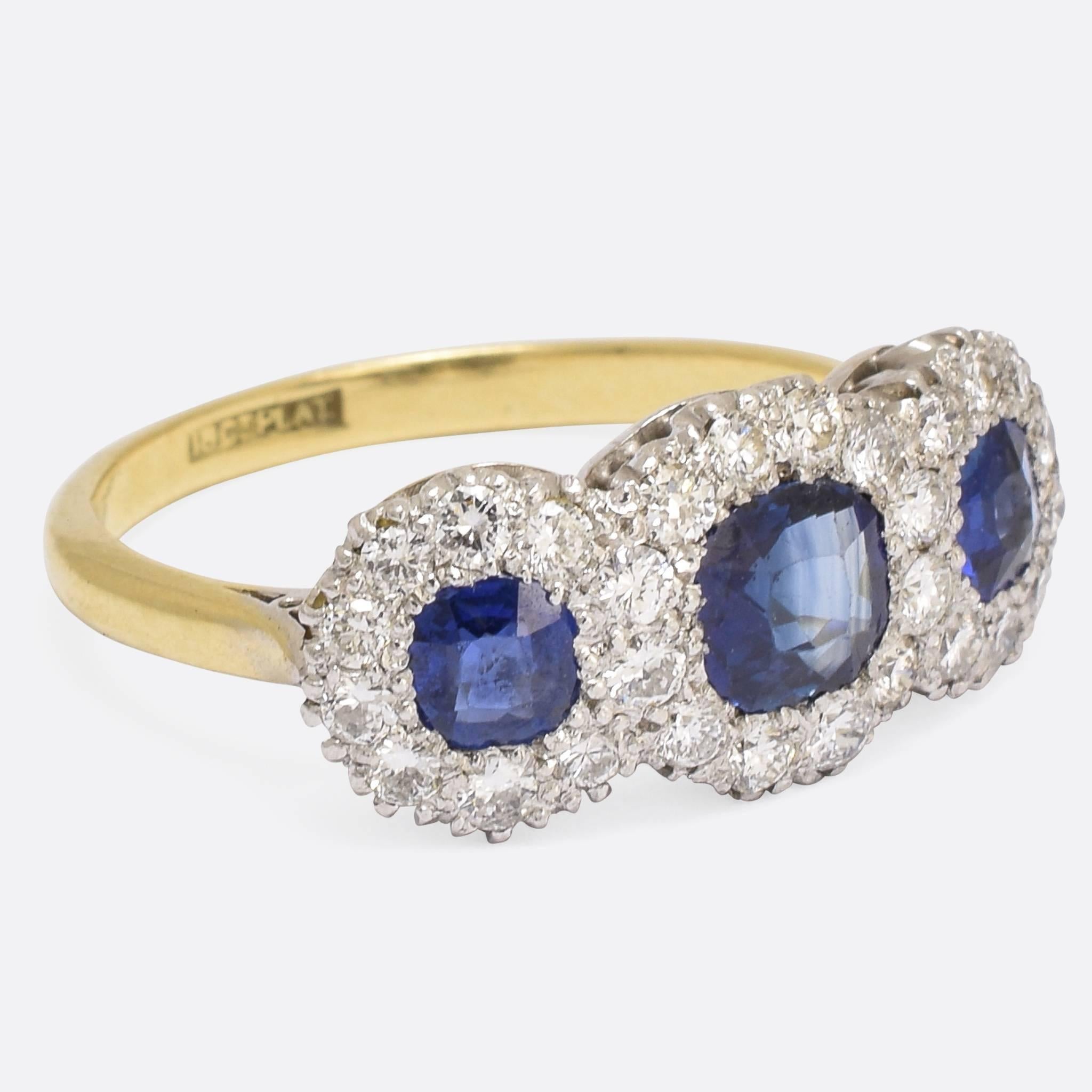 A spectacular antique three-stone cluster ring, set with natural blue sapphires within a cluster of diamonds. An ultra-bling example of the popular trilogy style, this ring was made in the early 20th Century - c.1910 - and is modelled in 18k gold