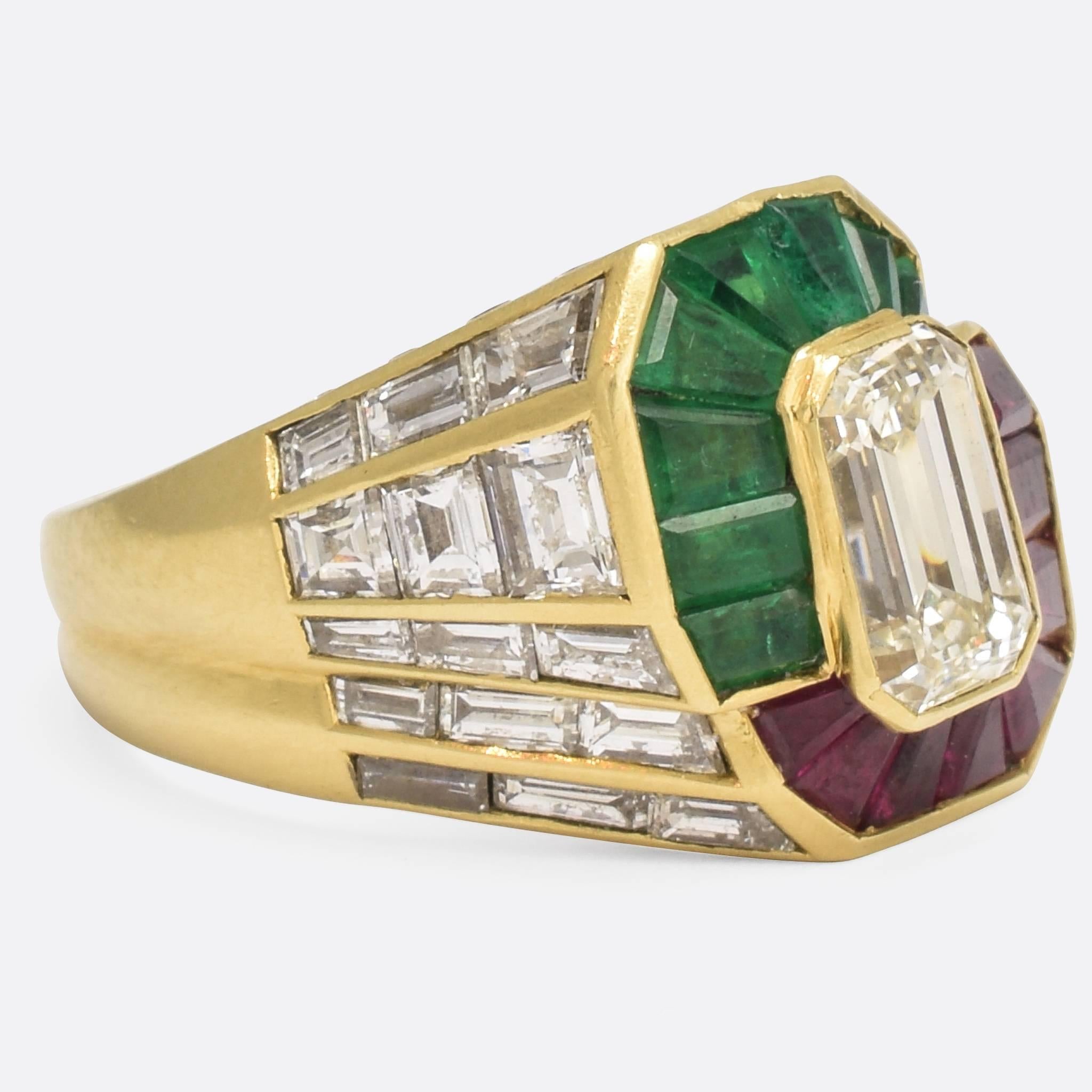 This 1980s cocktail ring is nothing short of incredible. An interlinked double halo of calibré cut emeralds and rubies surround a central 1.6 carat emerald cut diamond. The shoulders and gallery are set with calibré cut diamonds (calibré literally