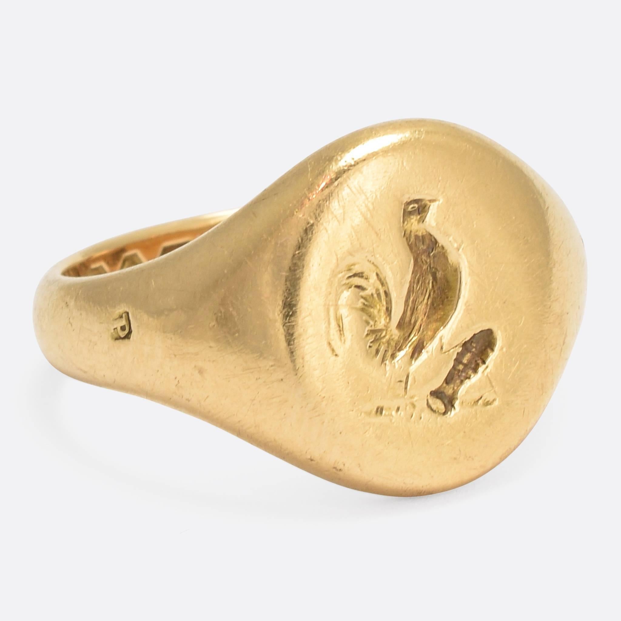 An interesting Edwardian era Signet Ring, modelled in 18k gold and carved with an English heraldic family crest: a rooster holding something (kinda looks like a fish...) in its foot. The ring has clear London hallmarks dating to the year 1910.