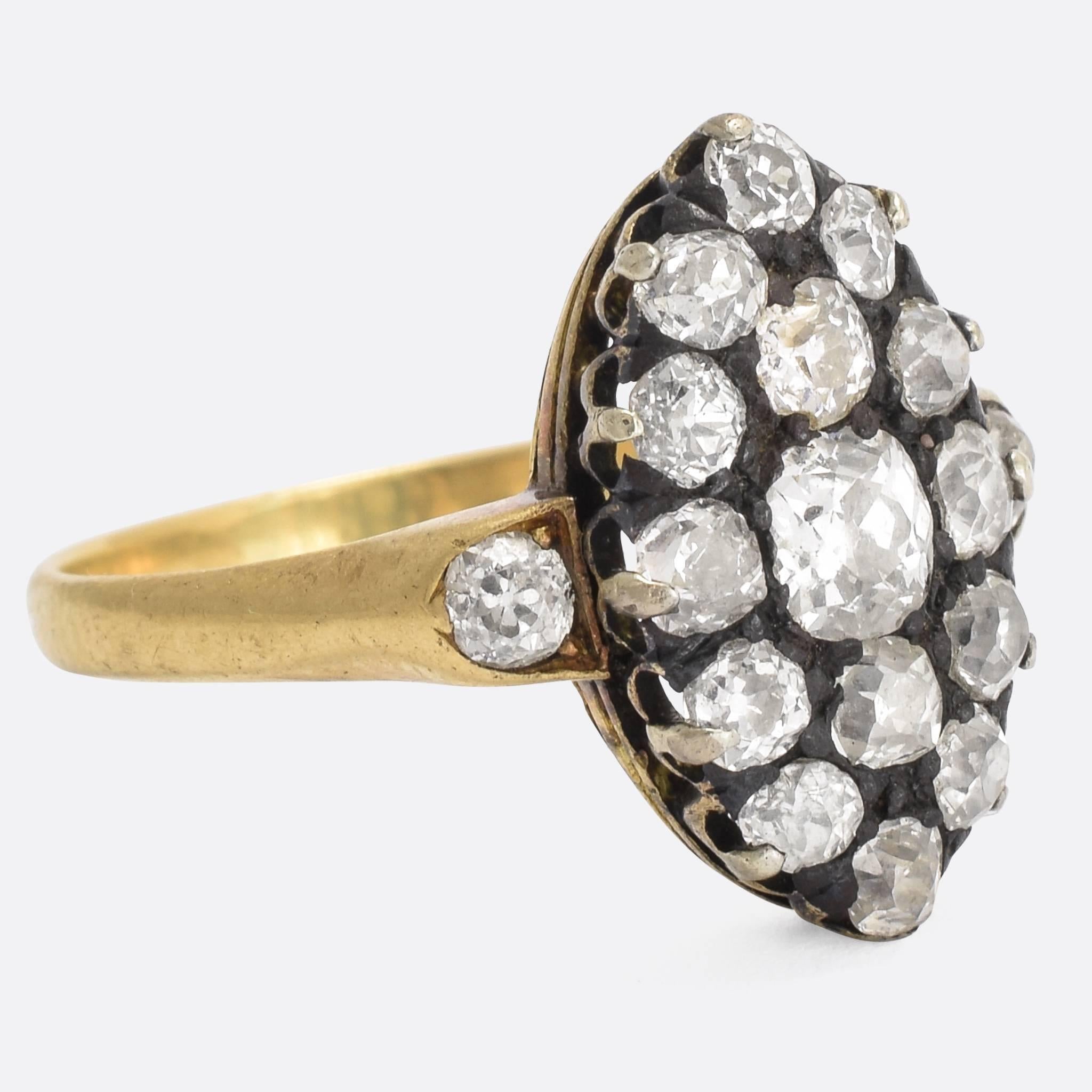 A splendid antique old cut diamond cluster ring, with marquise-shaped head and diamond shoulder accents. It dates to the Victorian era, c.1880, set with just over 2 carats of bright old mine cuts. The band is modelled in 18k yellow gold, and the
