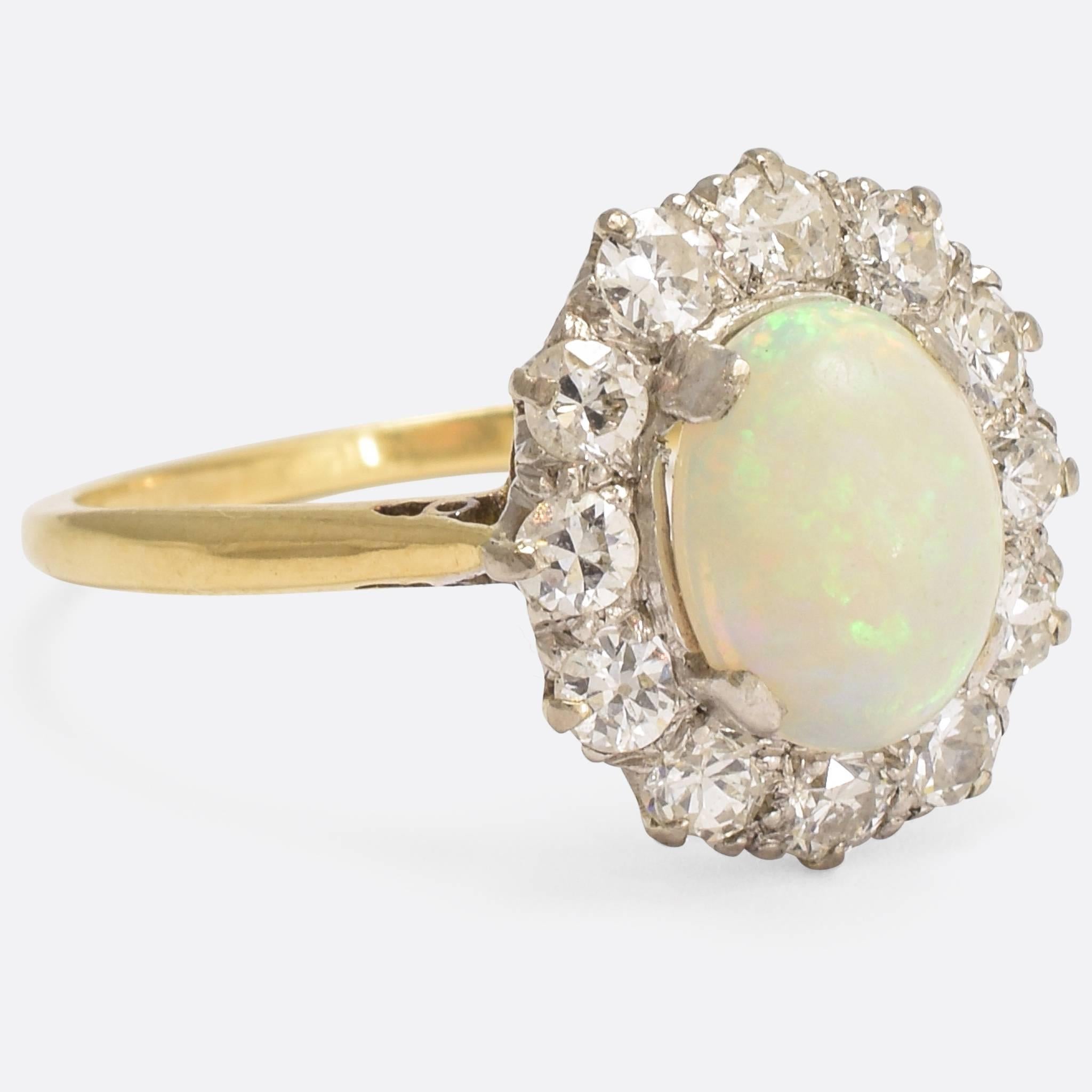 Simple, elegant, beautiful. A classic Edwardian opal and diamond halo ring modelled in 18k gold and platinum to create a lovely bi-metal contrast. The central stone is a deep cabochon cut - approx. 1.4ctw - full of fire and life, surrounded by a
