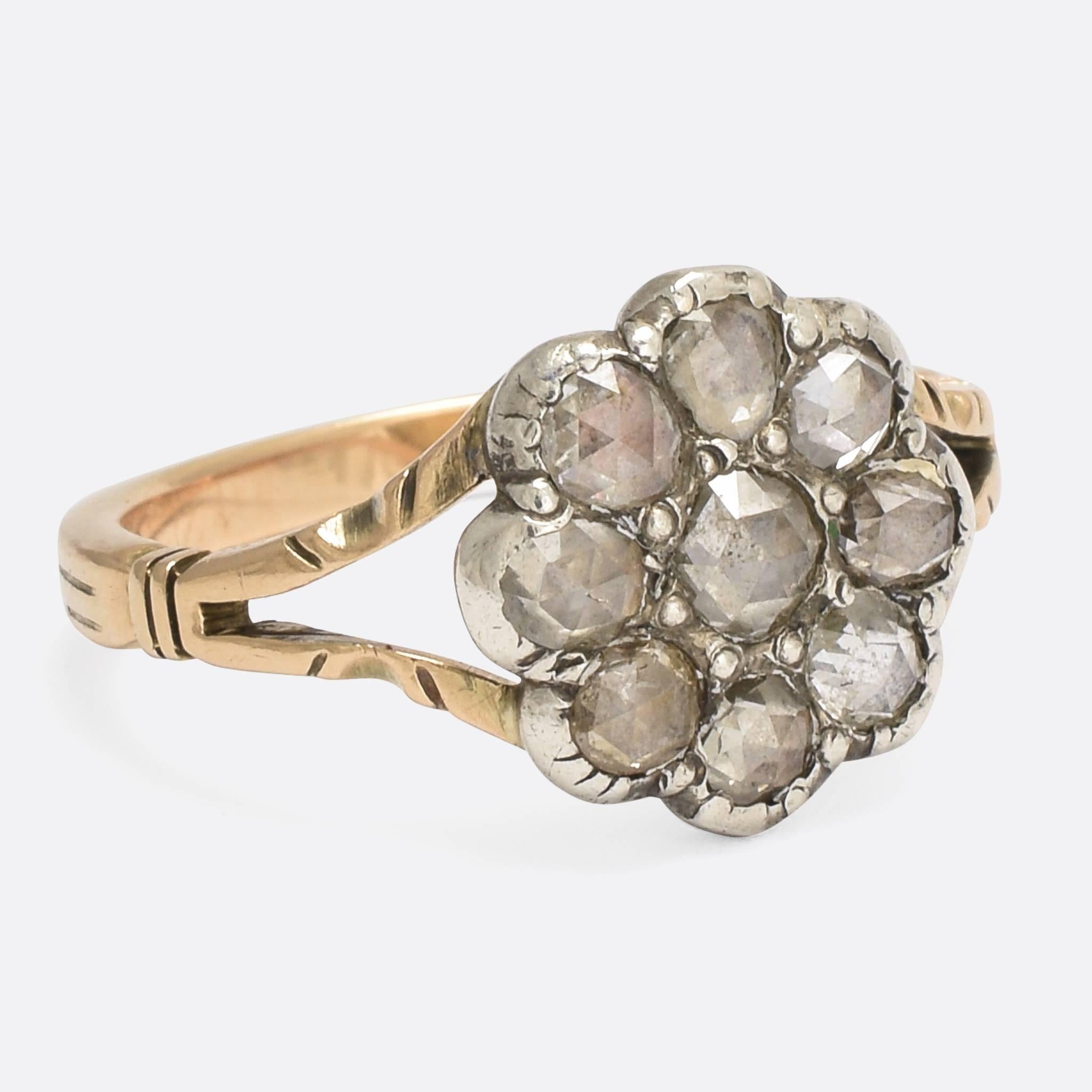 A beautiful Georgian flower ring, set with perfect, highly domed, rose cut diamonds. This one's more dainty than usual from this era, with elegant split shoulders and a reeded yellow gold band. The stones rest in foil-backed silver settings, further