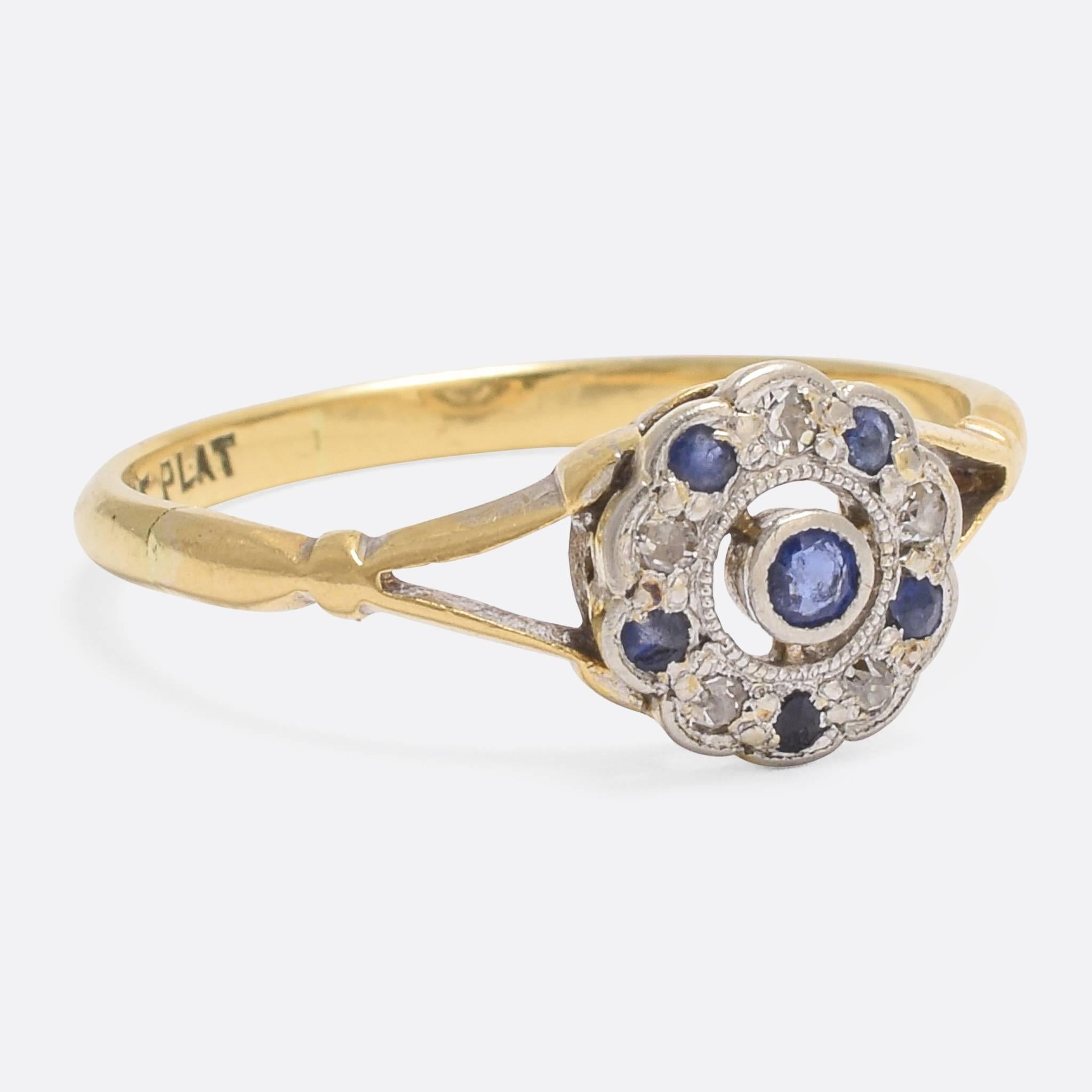 A cute Art Deco flower cluster ring, with a halo of blue sapphires and white diamonds set around a central sapphire. The head is finished in platinum, with millegrain detailing, and rests on an 18k yellow gold knife-edge band.

STONES
Blue Sapphires