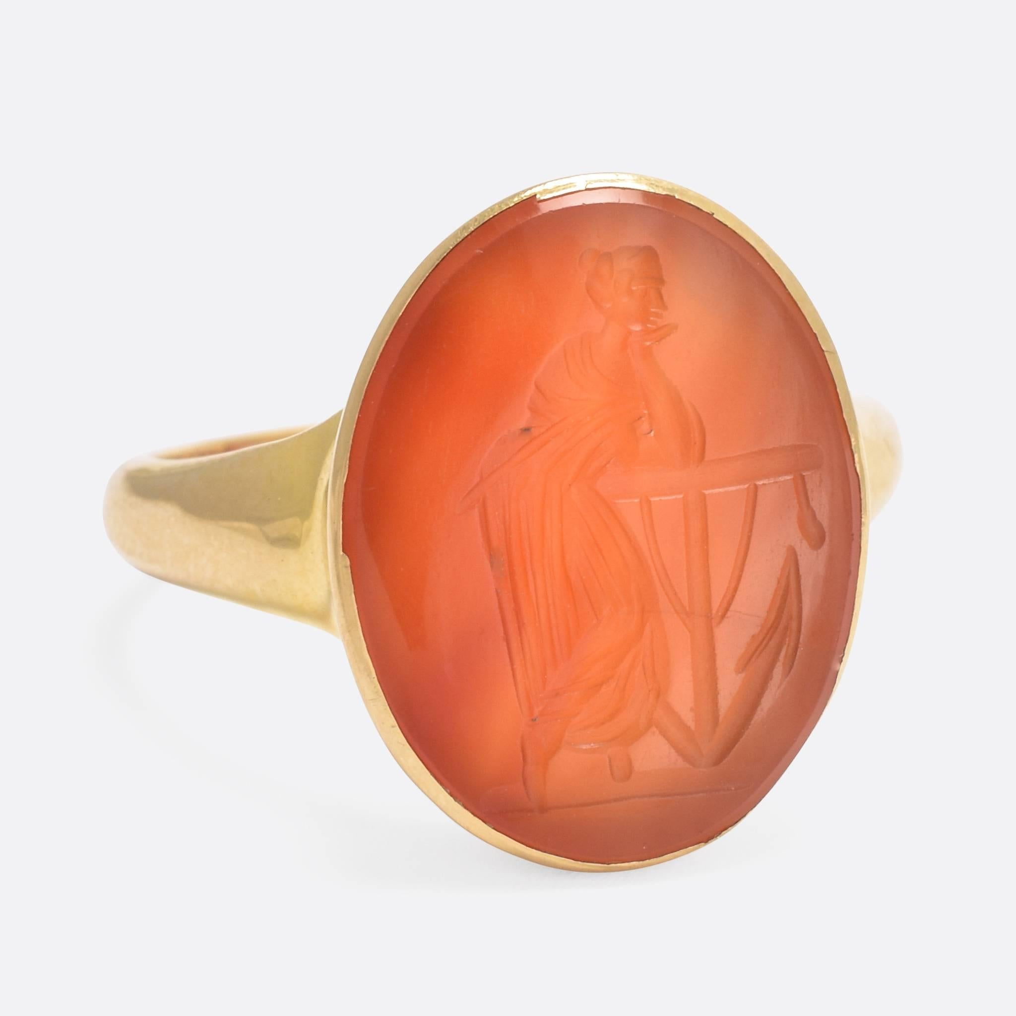 A superb antique intaglio ring, the subject is Lady Hope resting on an anchor awaiting the return of her beloved. The carnelian intaglio is mid-Victorian, circa 1850, and has been set in an Edwardian era ring mount - fully hallmarked for 18k gold,